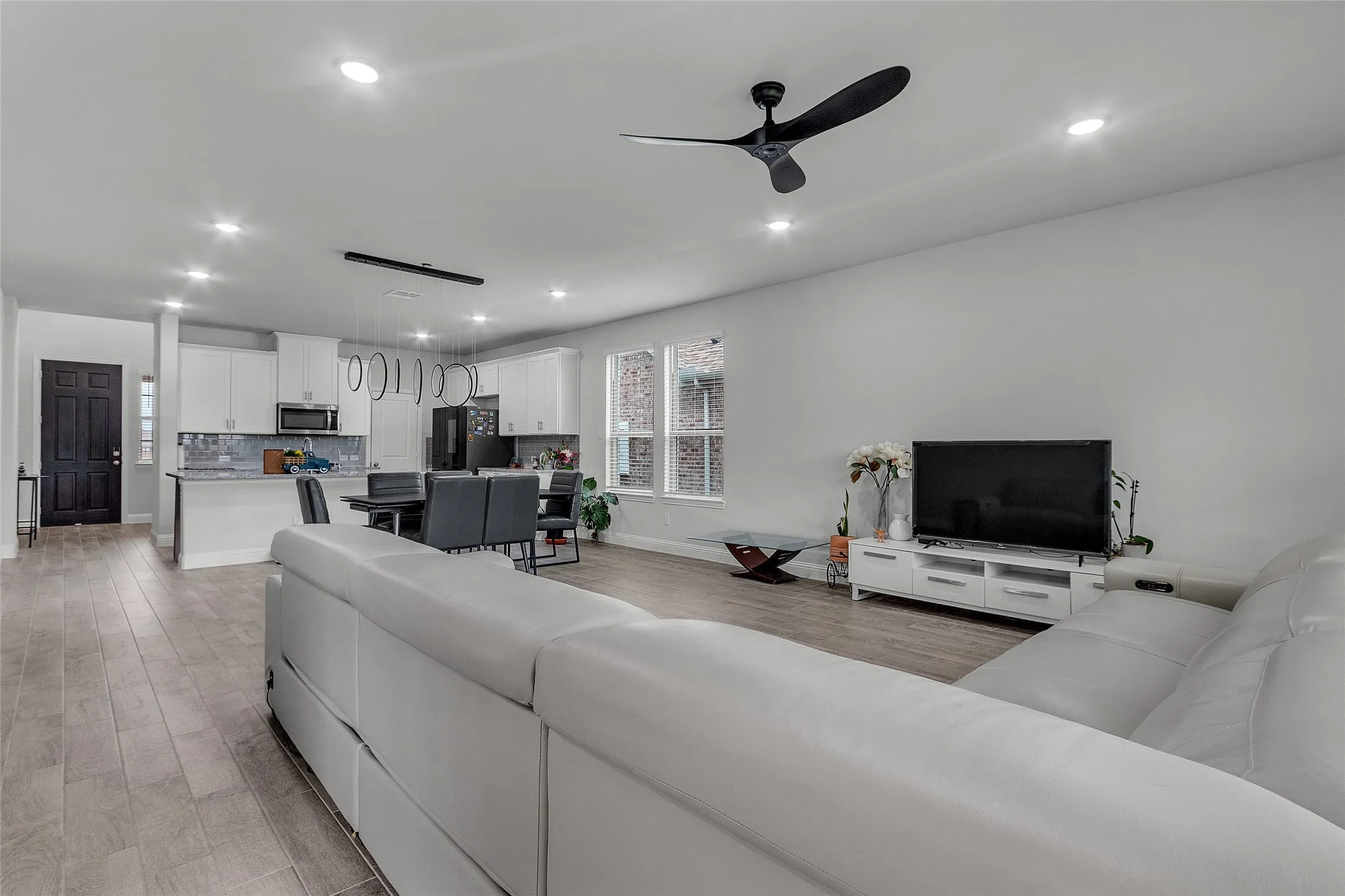 Living room with ceiling fan and light hardwood / wood-style flooring