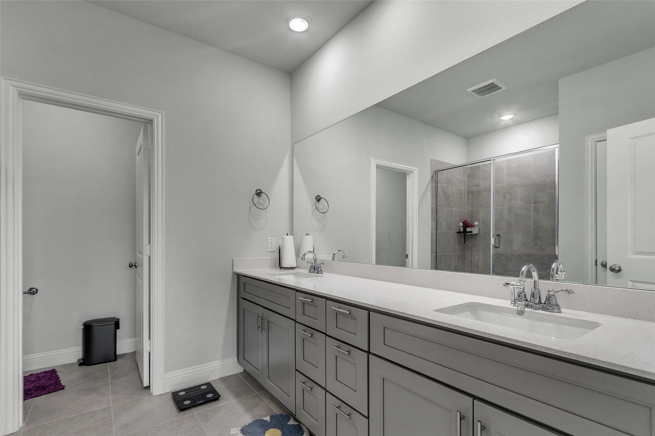 Bathroom featuring tile patterned flooring, an enclosed shower, and vanity