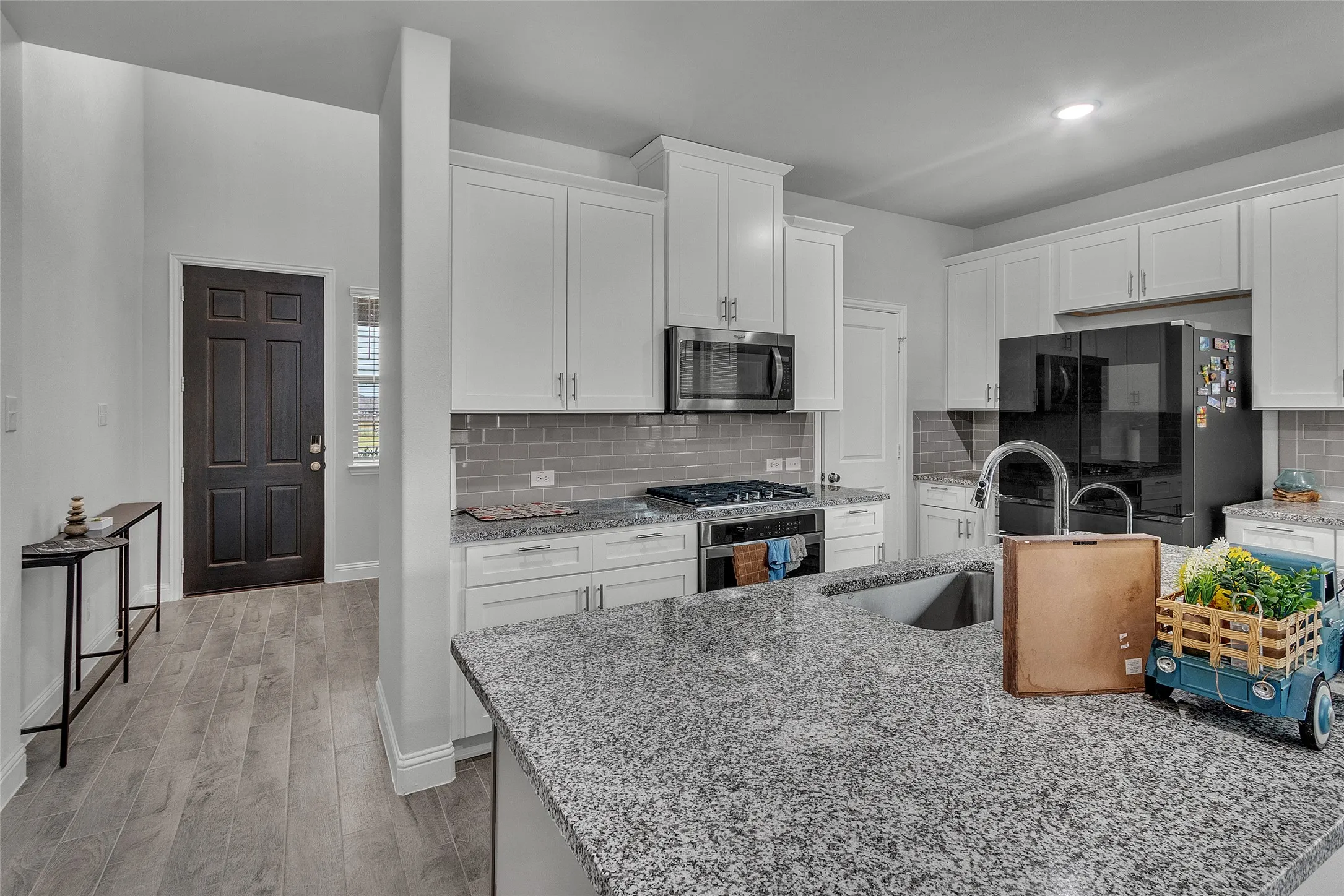 Kitchen featuring appliances with stainless steel finishes, sink, white cabinets, and light hardwood / wood-style floors