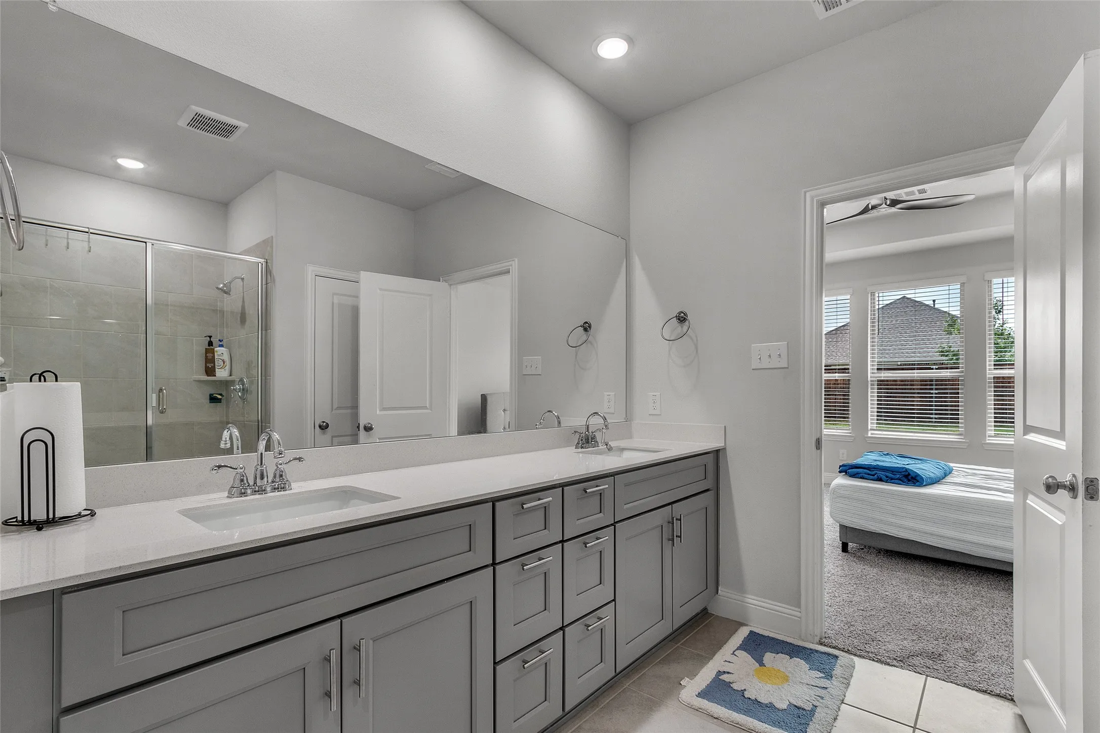 Bathroom with vanity, ceiling fan, tile patterned floors, and walk in shower