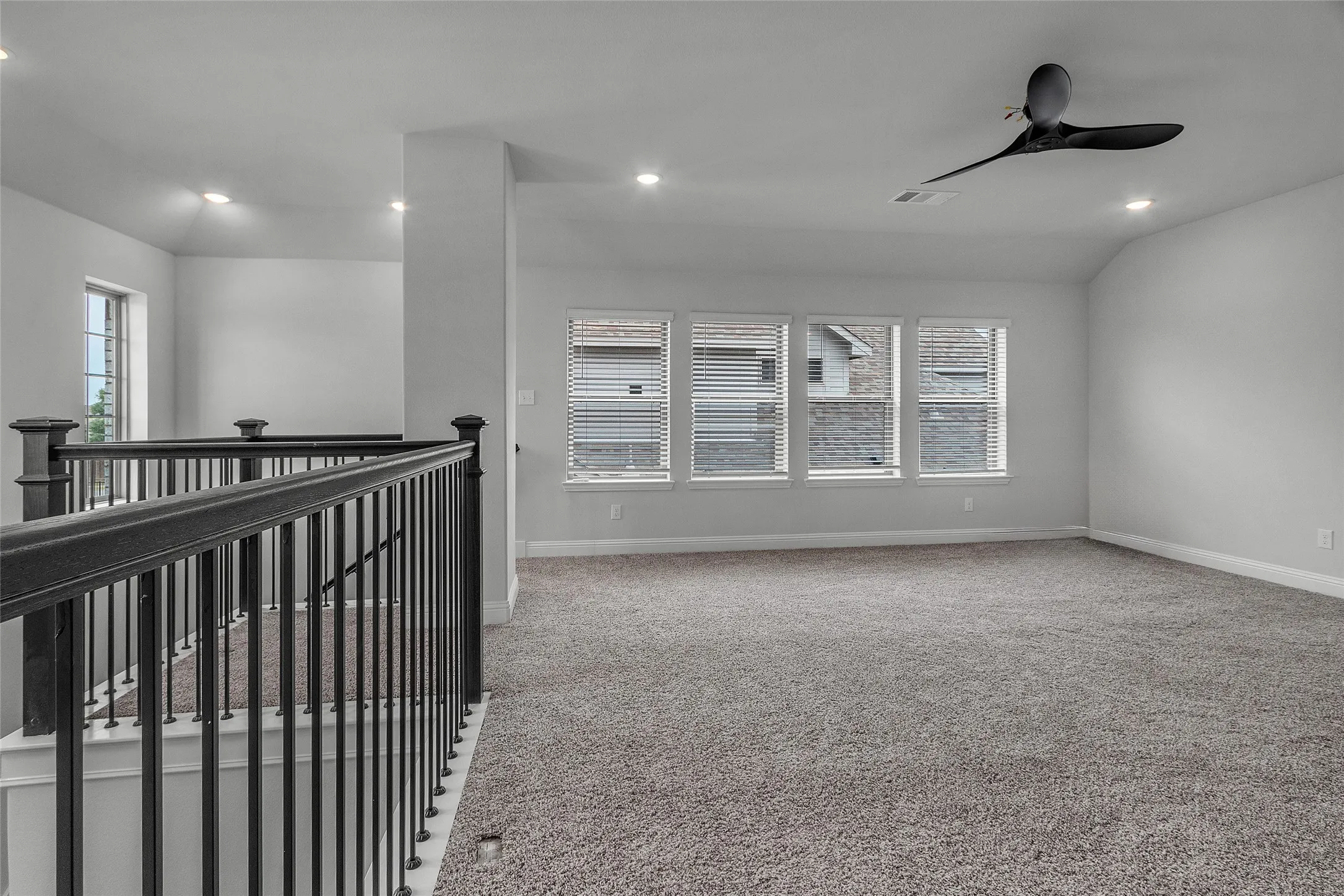 Hallway with vaulted ceiling and carpet flooring