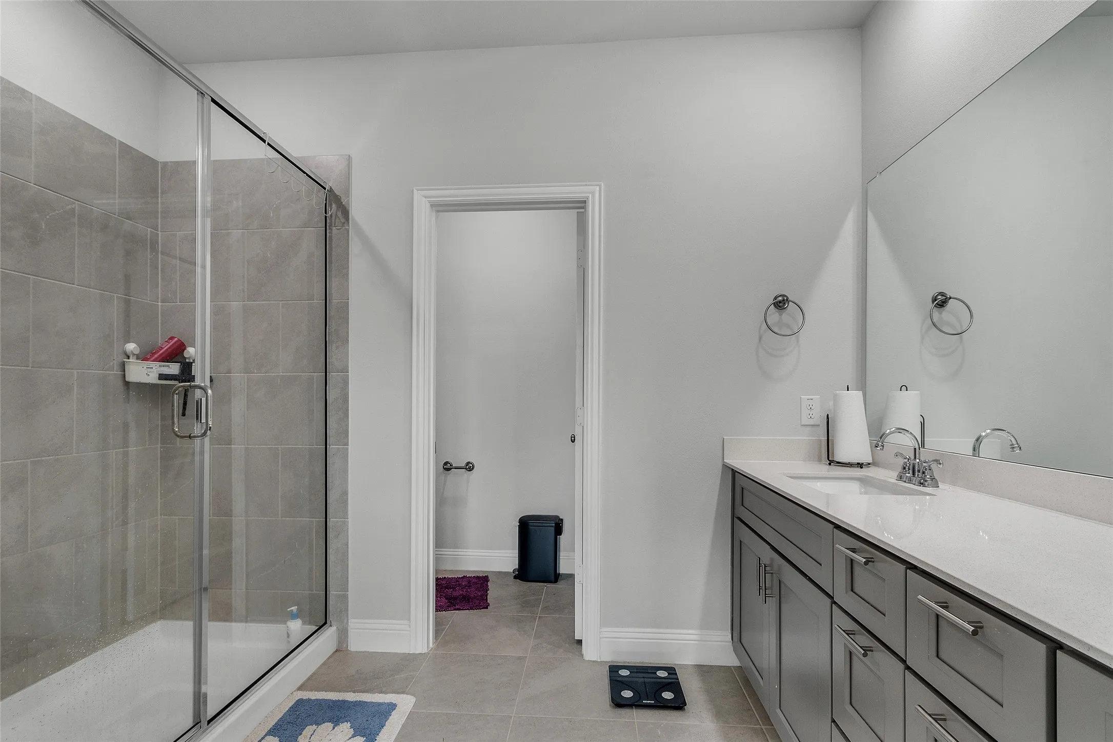 Bathroom featuring vanity, an enclosed shower, and tile patterned flooring