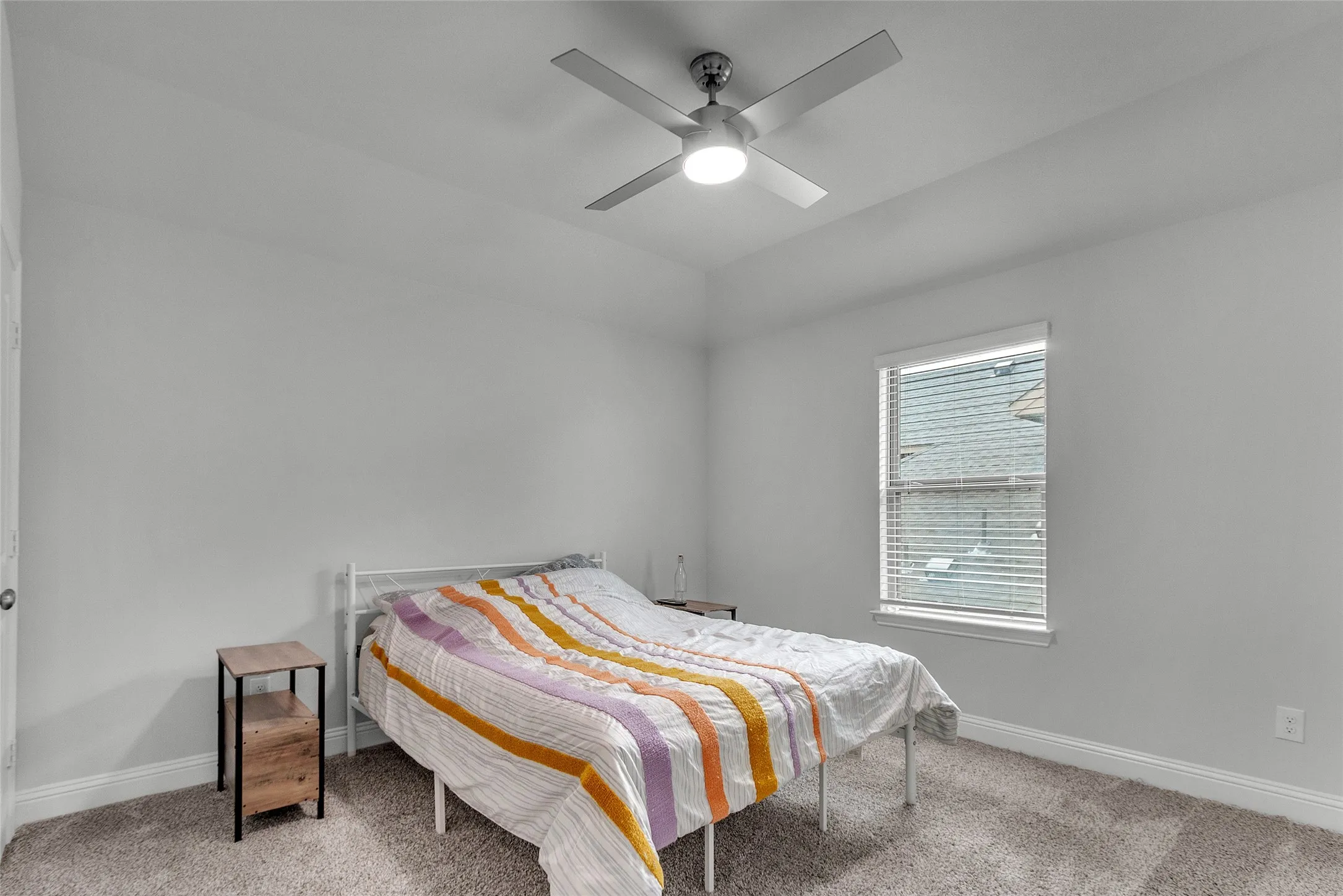 Carpeted bedroom featuring lofted ceiling and ceiling fan