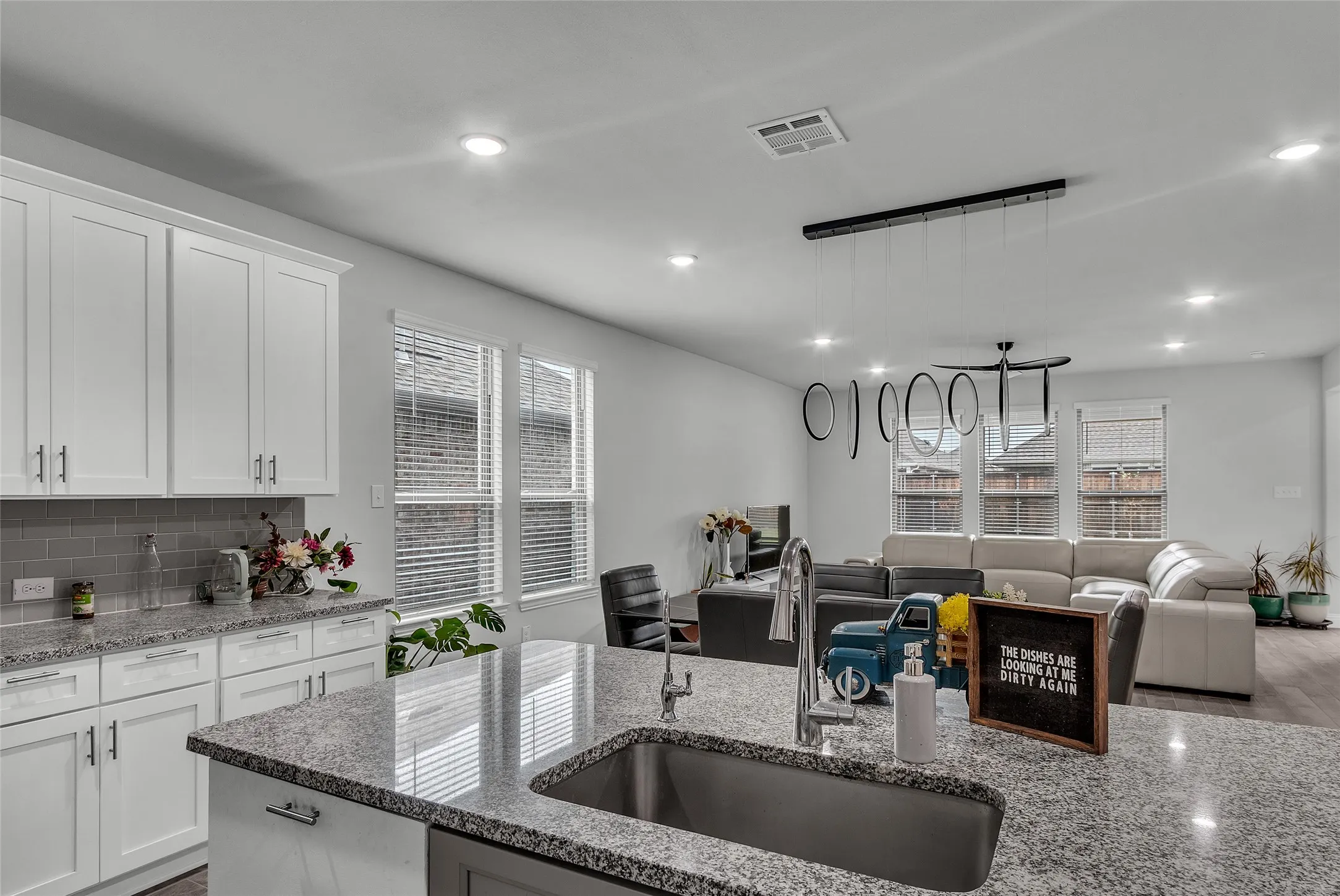Kitchen featuring plenty of natural light, white cabinetry, and sink