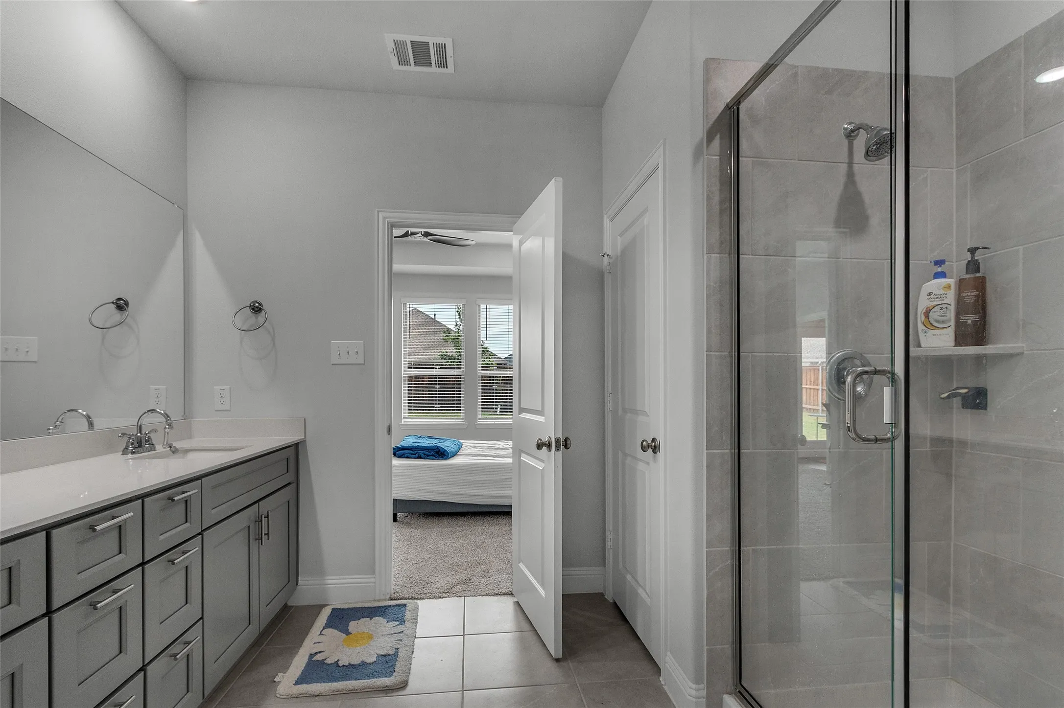 Bathroom with tile patterned flooring, vanity, and a shower with shower door