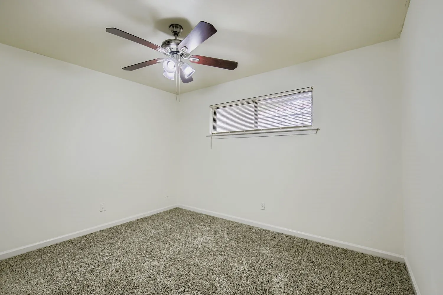 Room with light beige walls and gray carpet flooring