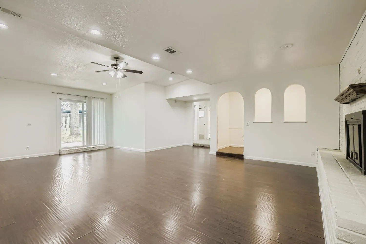 Spacious room featuring wood-finish flooring, recessed lighting, and a ceiling fan