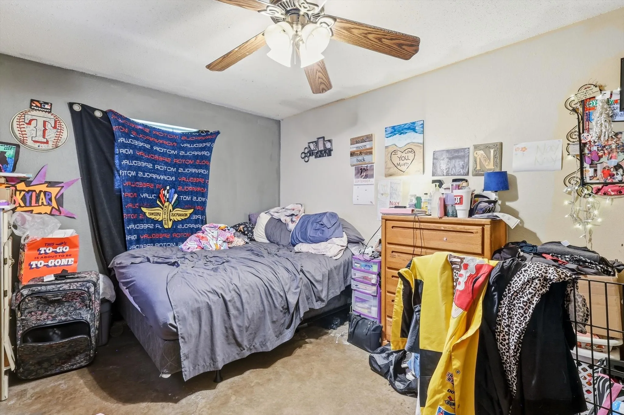 Bedroom featuring a ceiling fan with wood-finish blades and light-toned walls