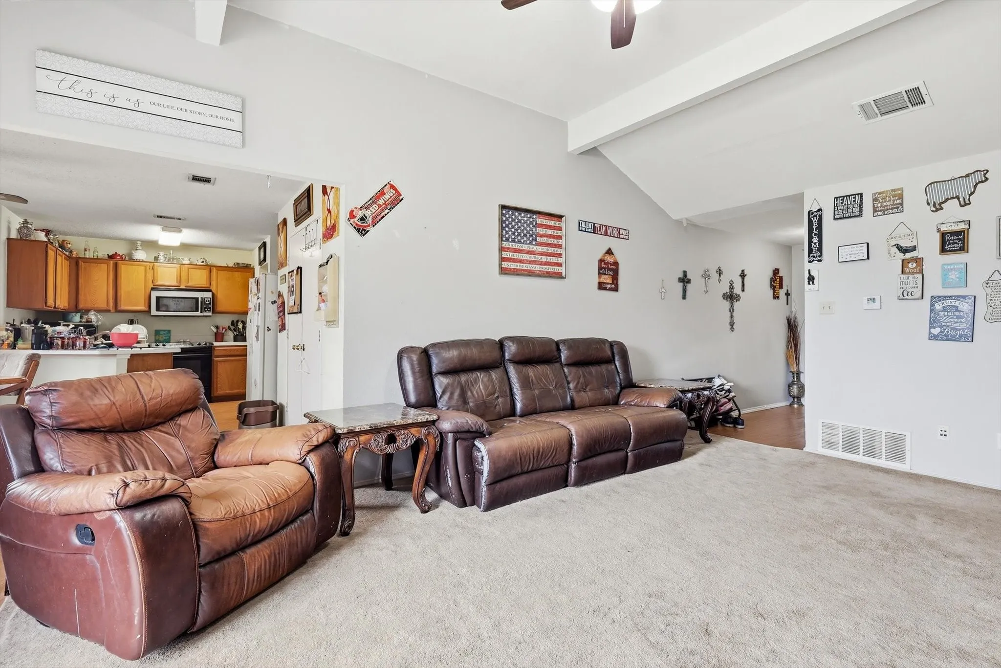 Spacious living area featuring vaulted ceilings and carpet