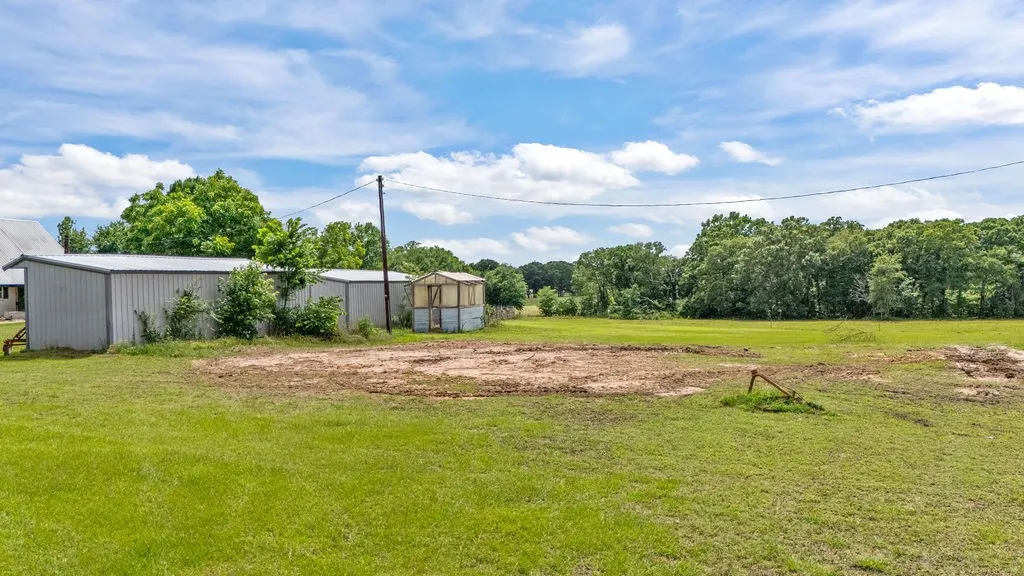 Located behind 2 pole sheds
