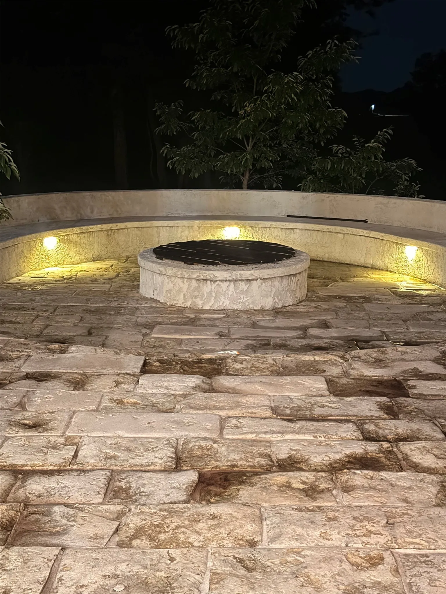 Wonderful firepit at night with ample built-in seating