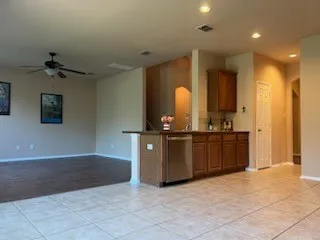 Kitchen featuring dishwasher, light tile floors, and ceiling fan