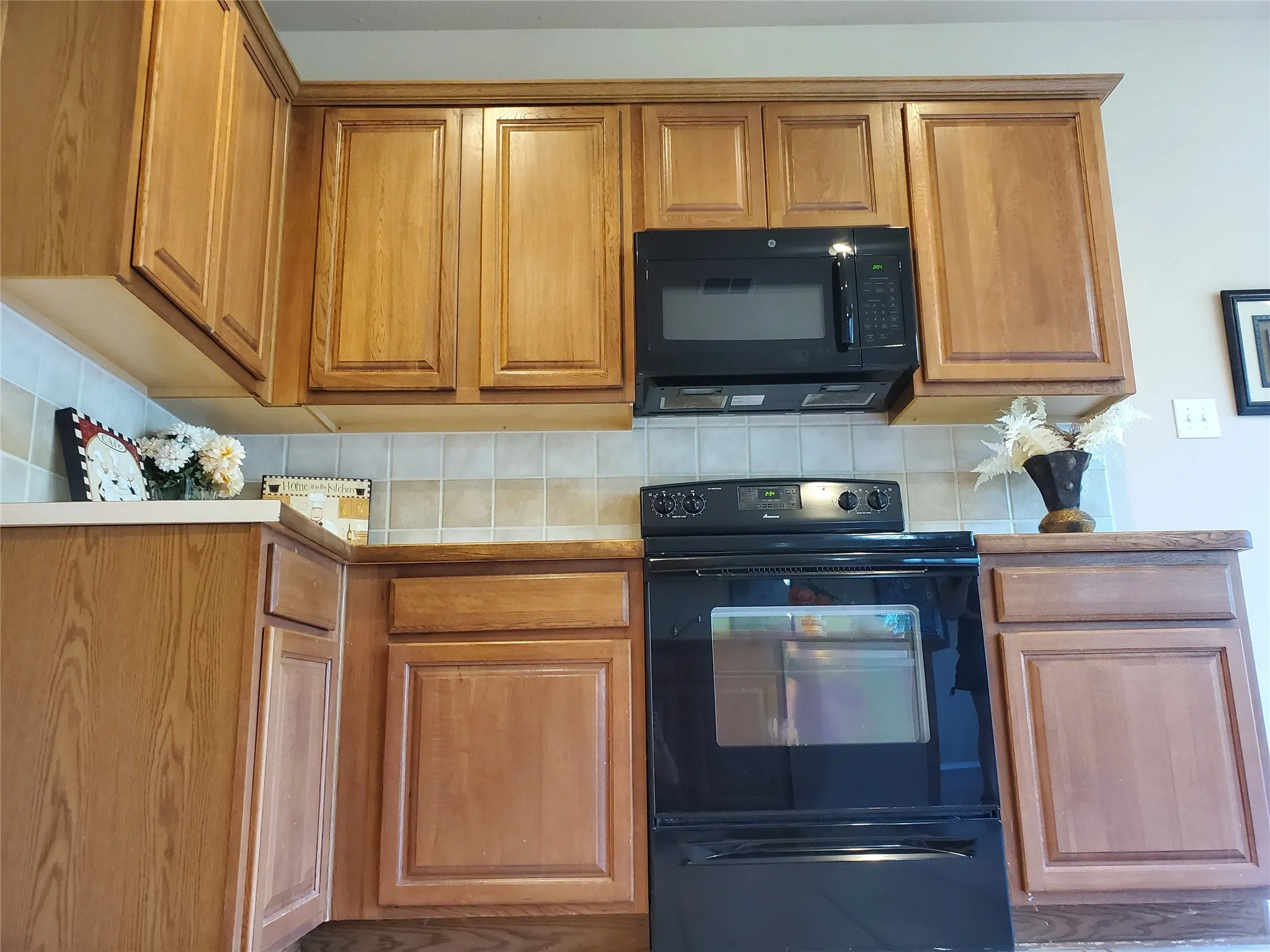 Kitchen with black appliances (microwave, oven with glass cook-top stove).  New Microwave