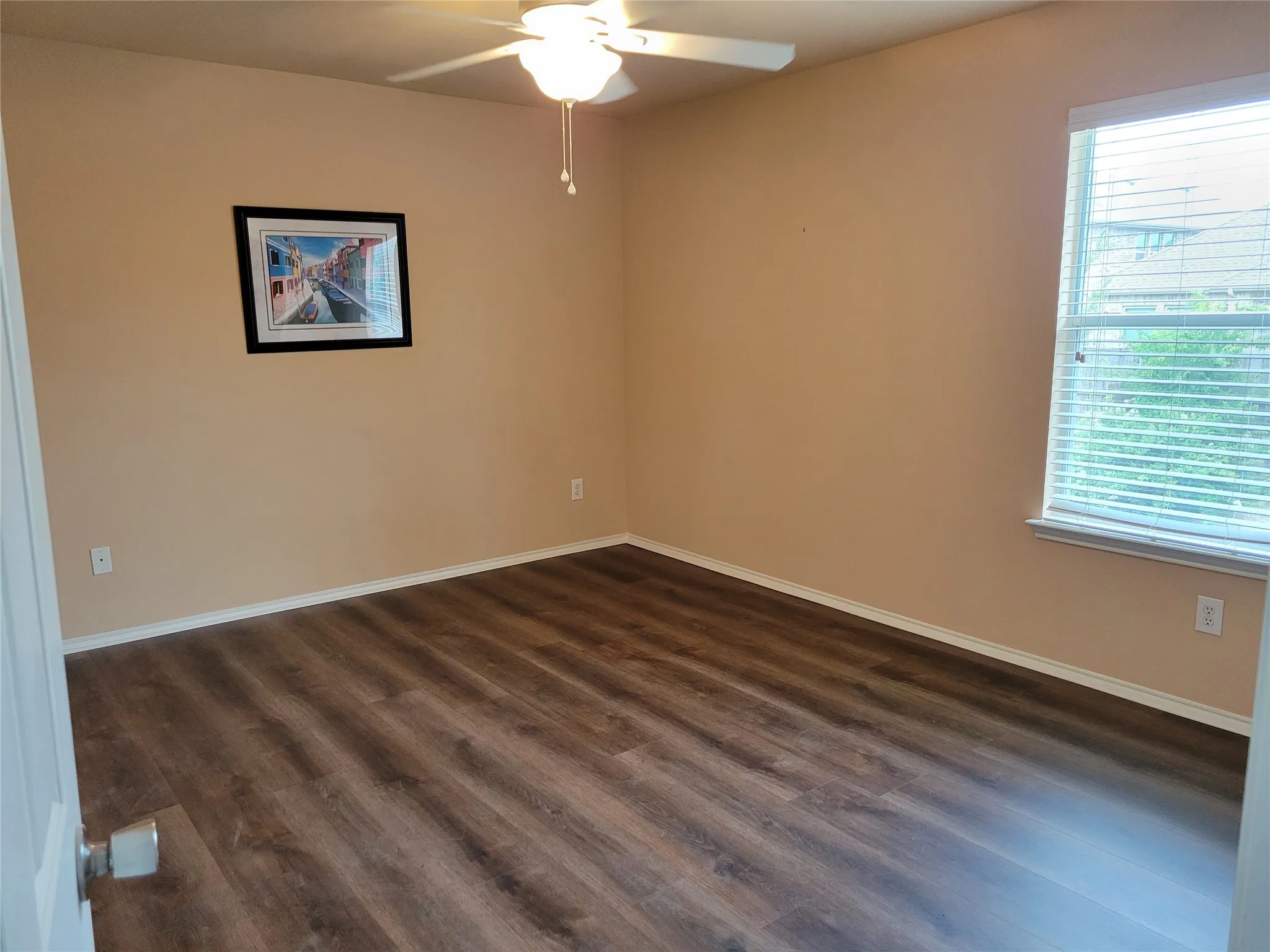 One of 3 bedrooms upstairs featuring laminate flooring, ceiling fan, walk-in closet, and plenty of natural light