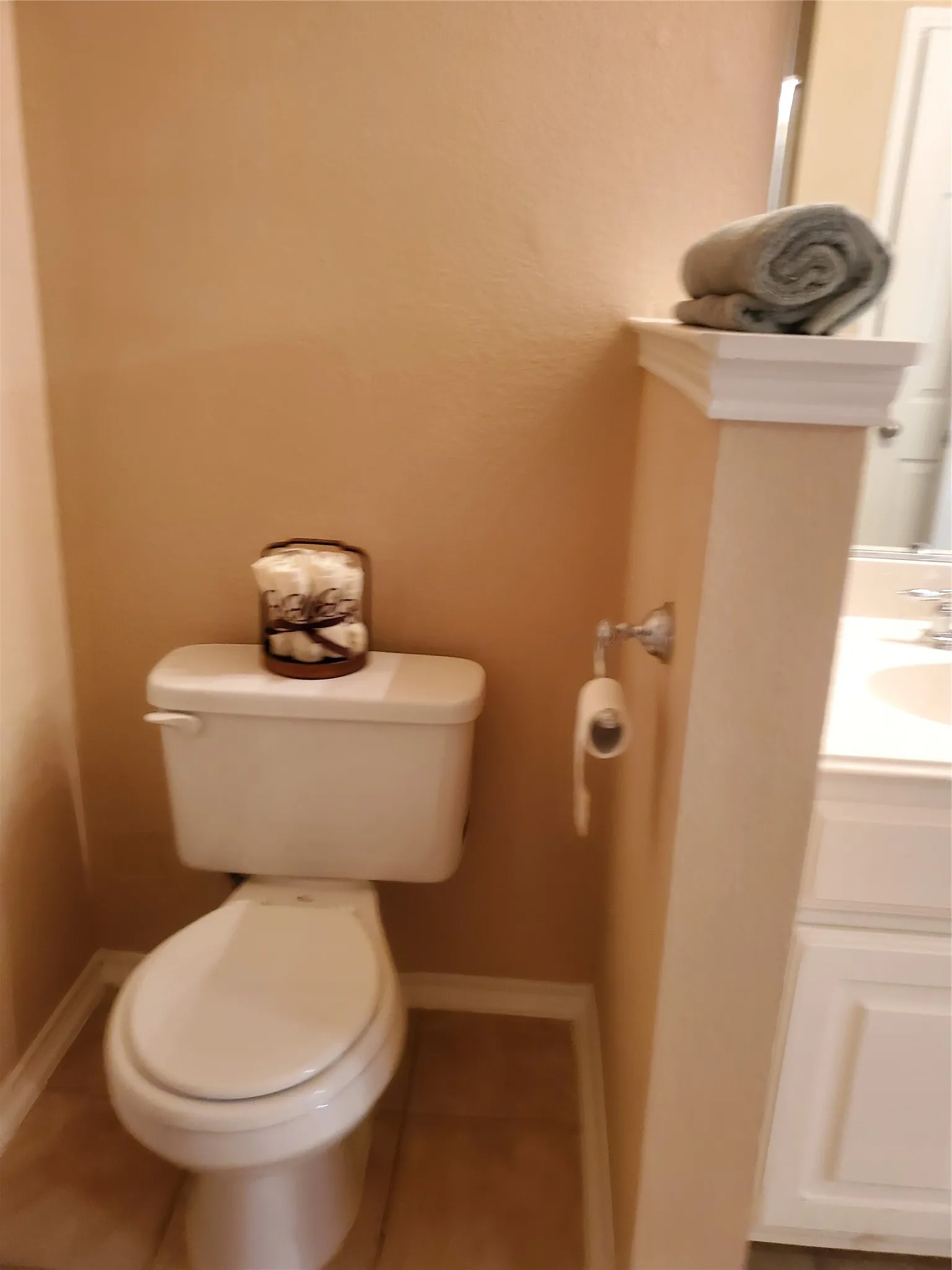 Bathroom with vanity with extensive cabinet space, toilet, and tile floors