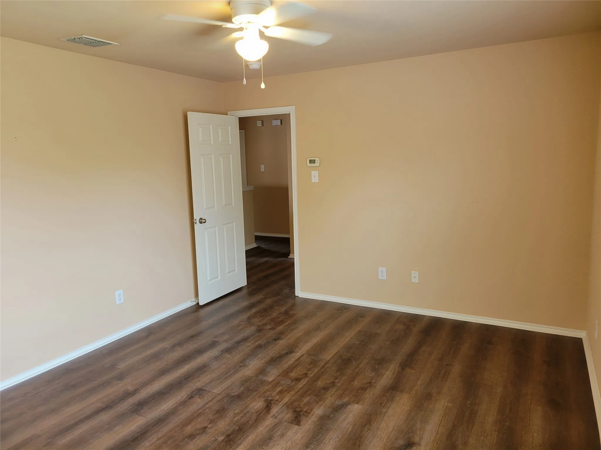 One of 3 bedrooms upstairs featuring laminate flooring, ceiling fan, walk-in closet, and plenty of natural light