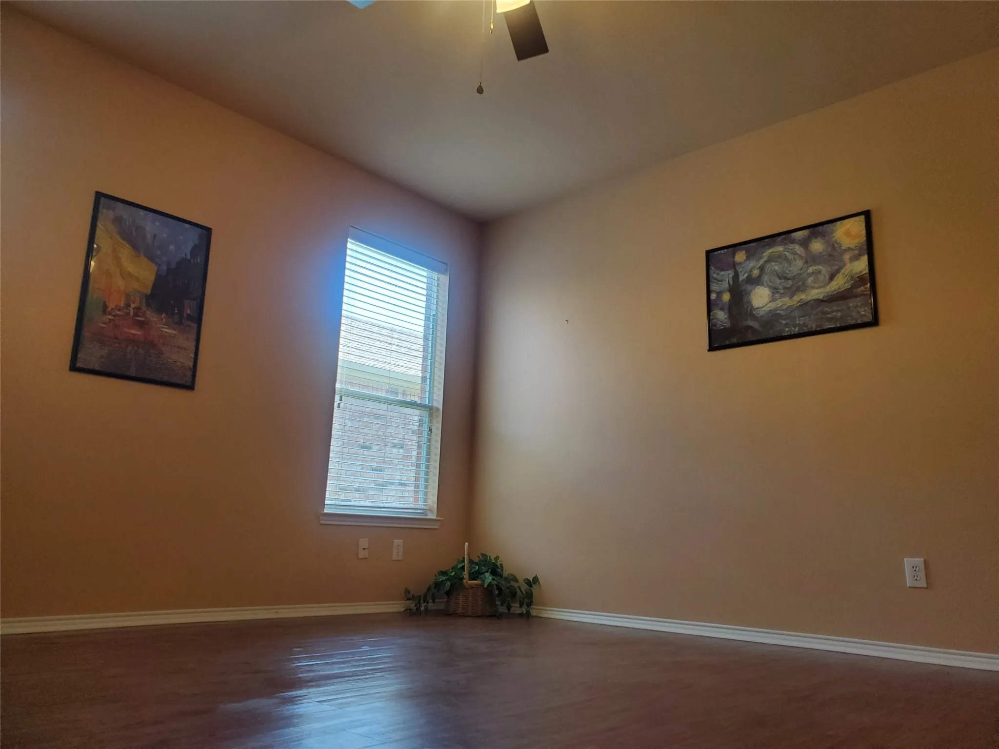 Primary bedroom with laminate flooring and ceiling fan.