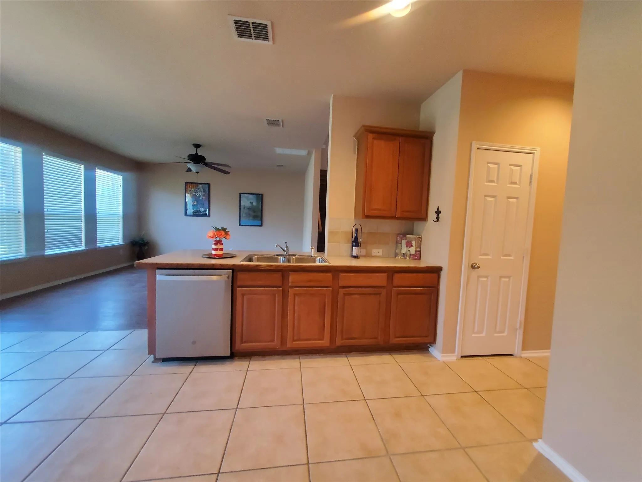Kitchen featuring tile floor, relatively new stainless steel dishwasher, open to living area