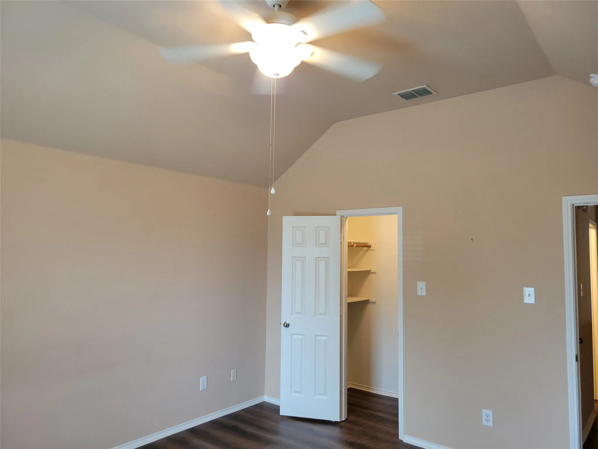 One of 3 bedrooms upstairs featuring laminate flooring, ceiling fan, walk-in closet, and plenty of natural light