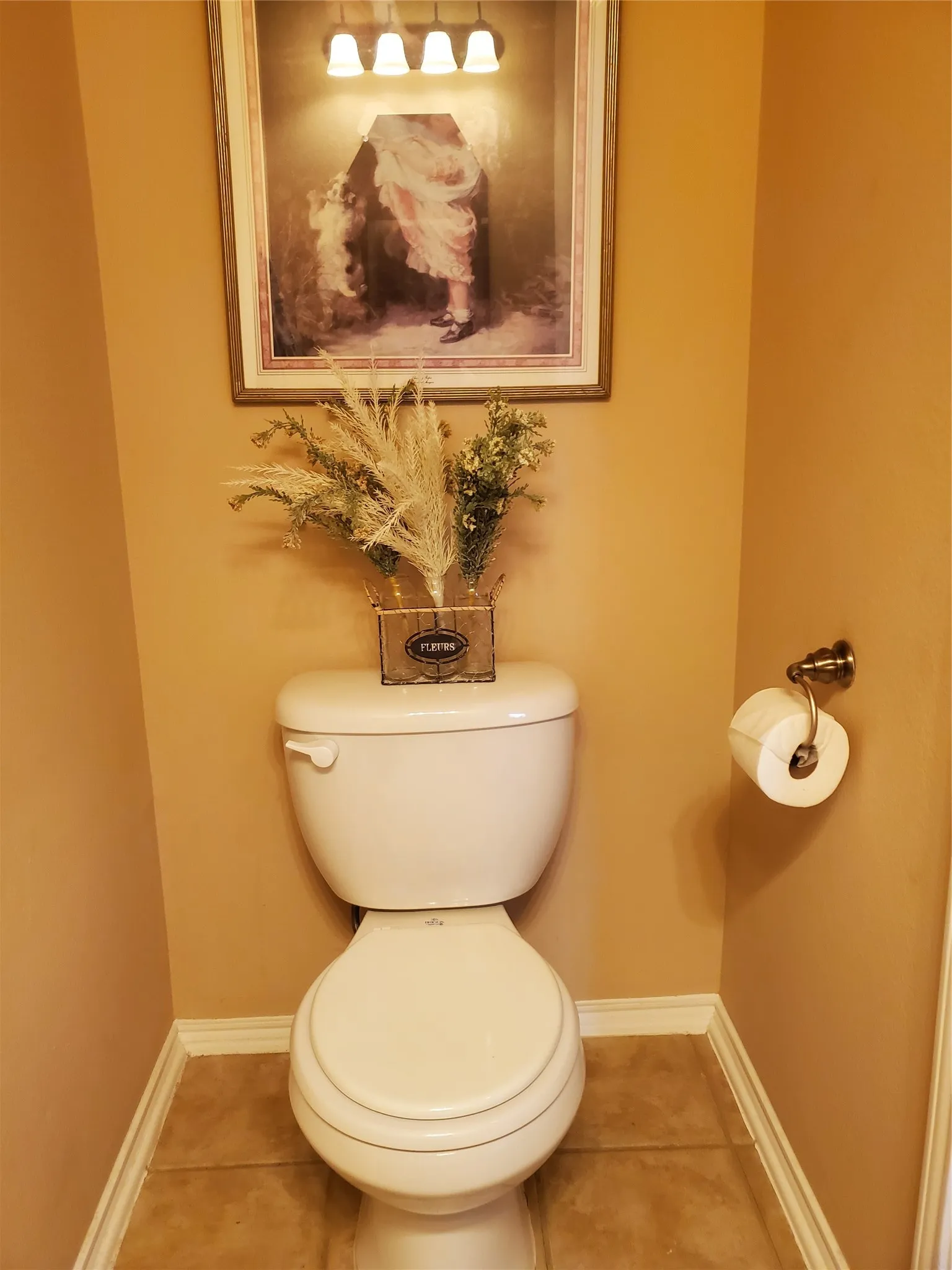View of powder bathroom toilet with tile floors