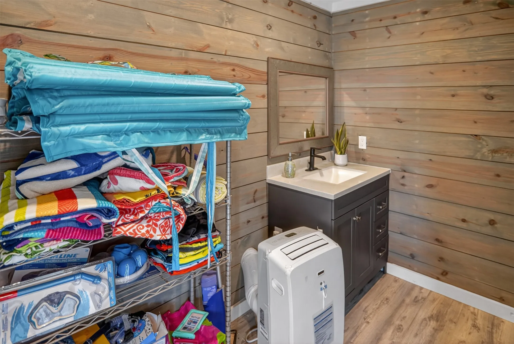Pool house bathroom, wood-finish plank walls complement the light-toned wood-finish flooring