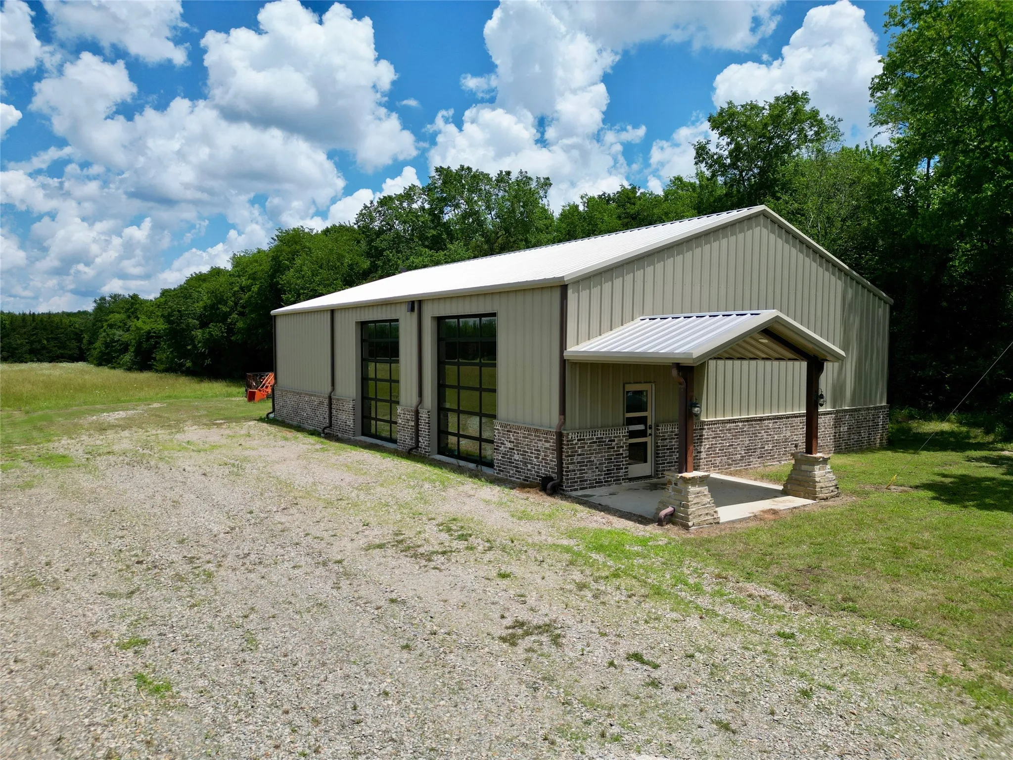 40x60 Detached metal-sided structure featuring two full-light garage doors and a covered entryway,  with RV door in back