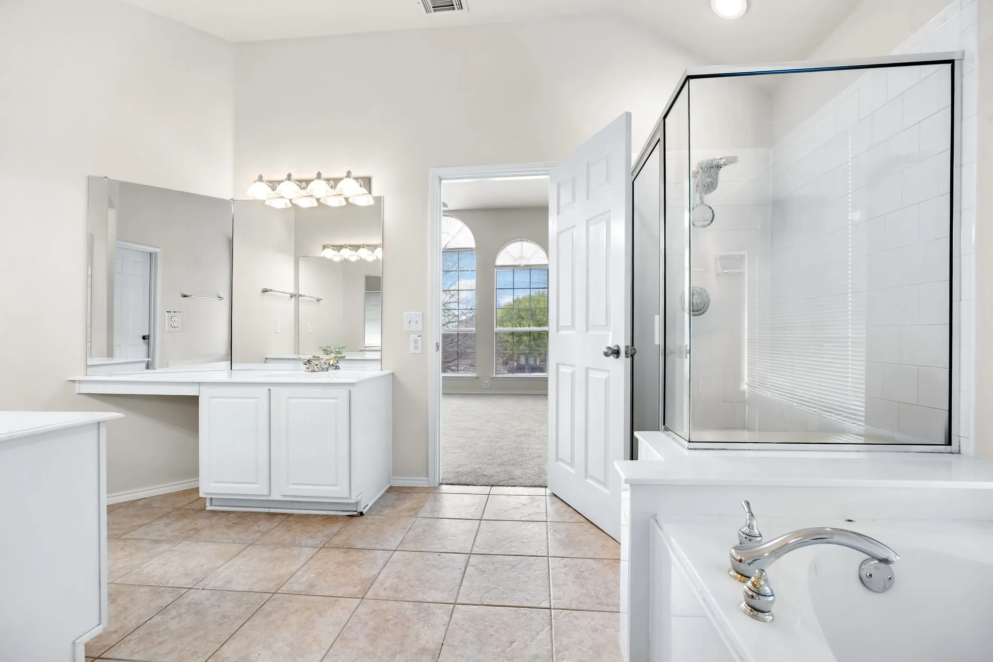 Full bathroom featuring vanity, a shower stall, light tile patterned flooring, and a garden tub