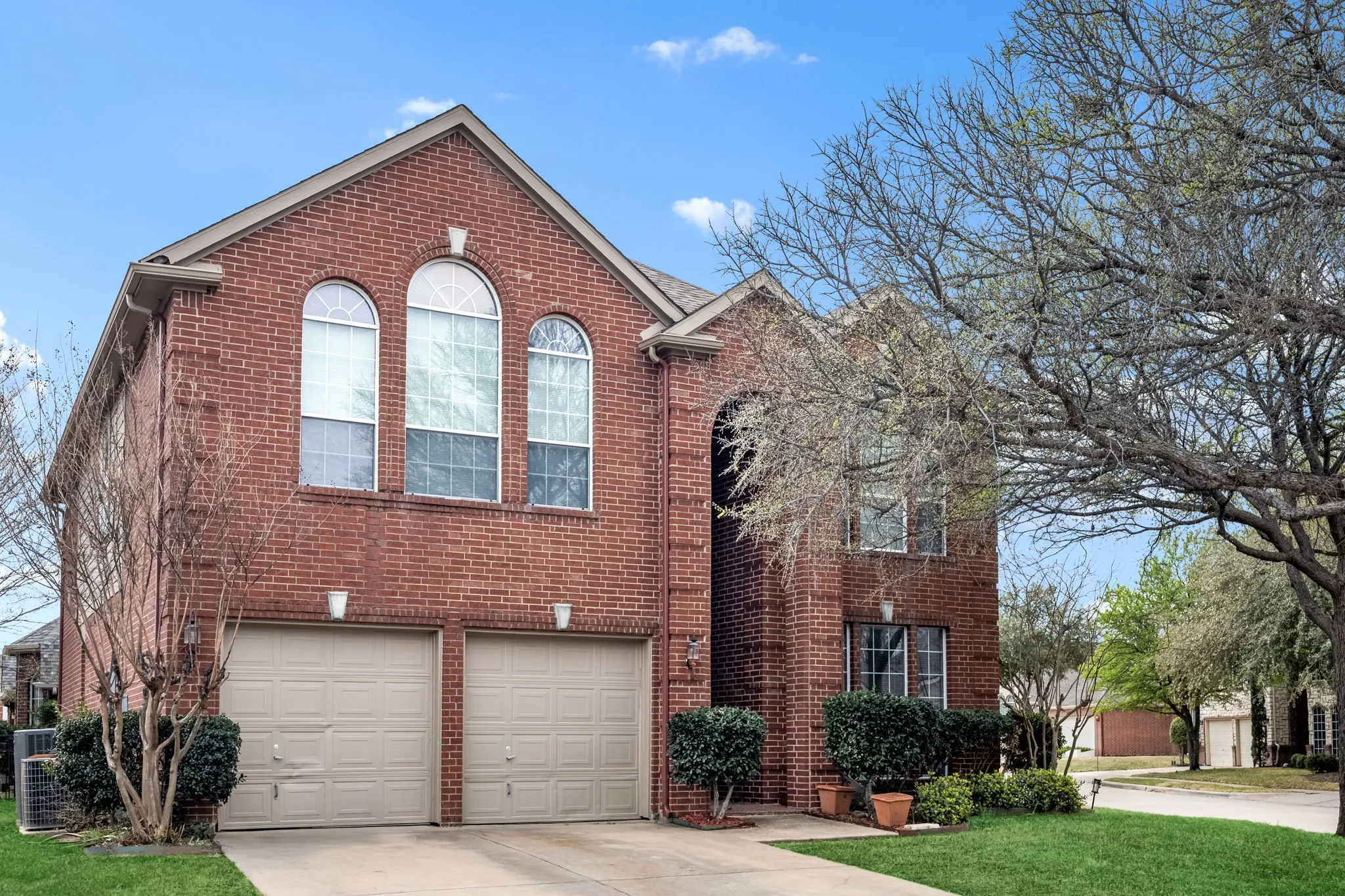 View of front of property with brick siding, concrete driveway, an attached garage, and a front yard