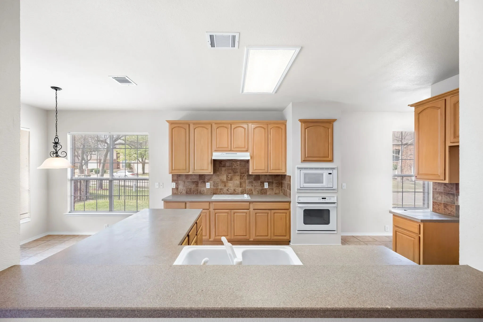 Kitchen featuring light countertops, white appliances, and decorative backsplash