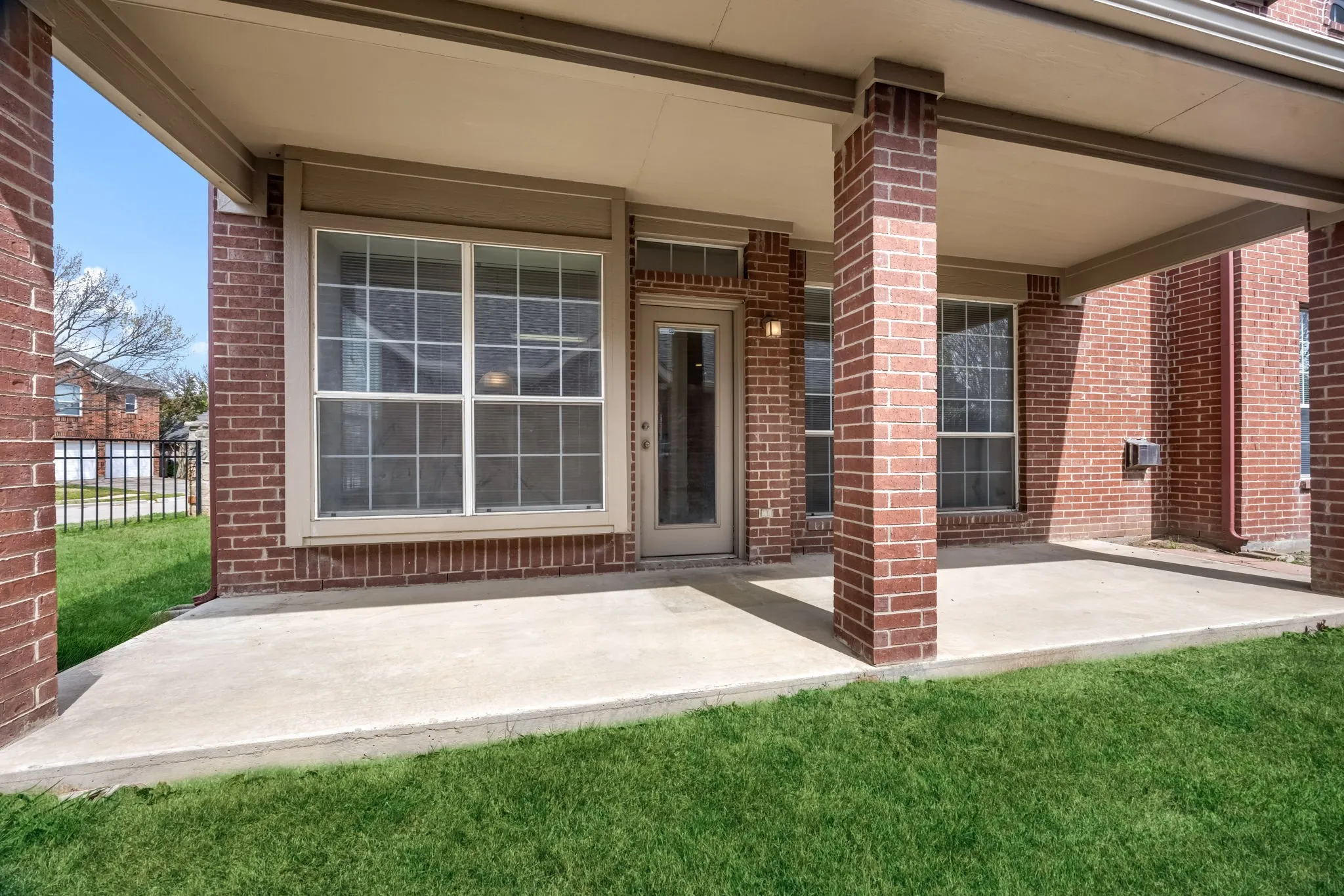 Entrance to property with brick siding and a patio area