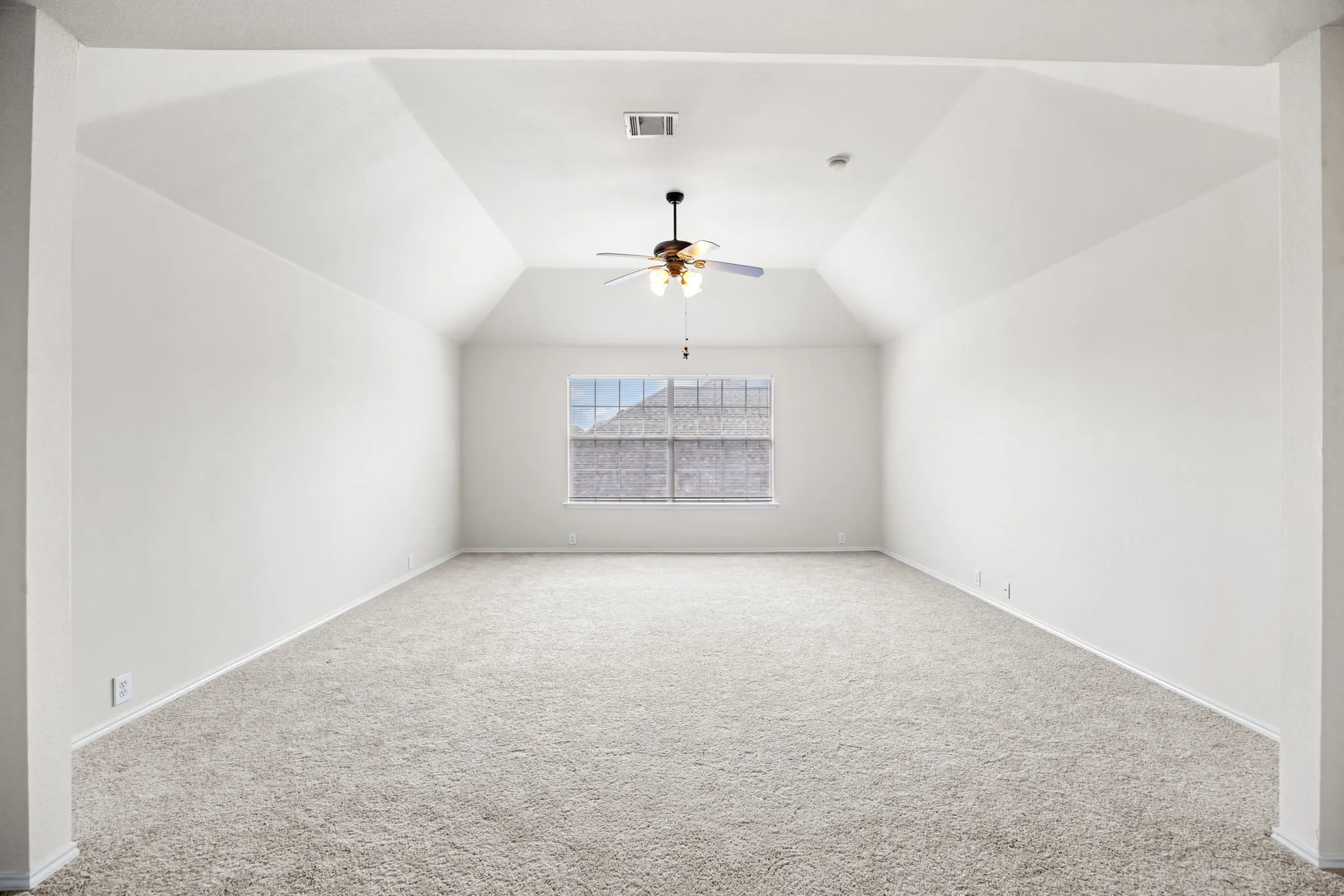 Carpeted empty room with ceiling fan and baseboards
