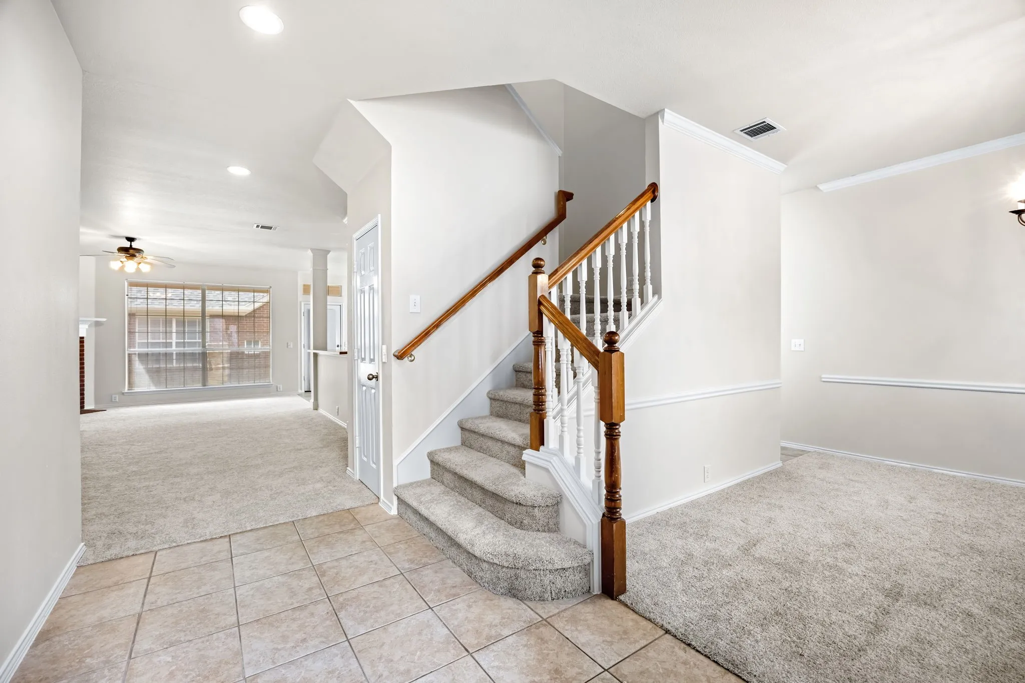 Stairway featuring carpet floors, tile patterned flooring, and ceiling fan
