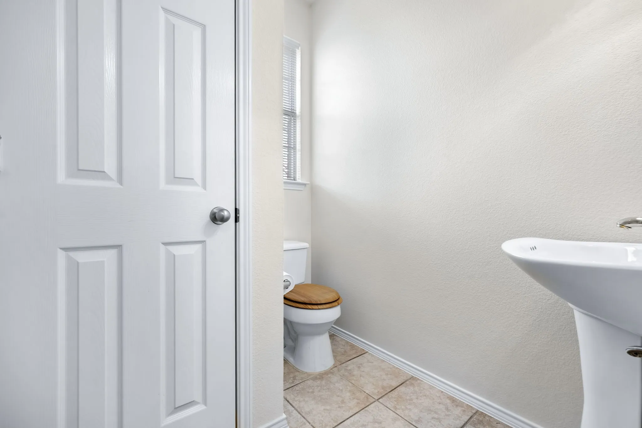 Bathroom featuring light tile patterned flooring and a textured wall