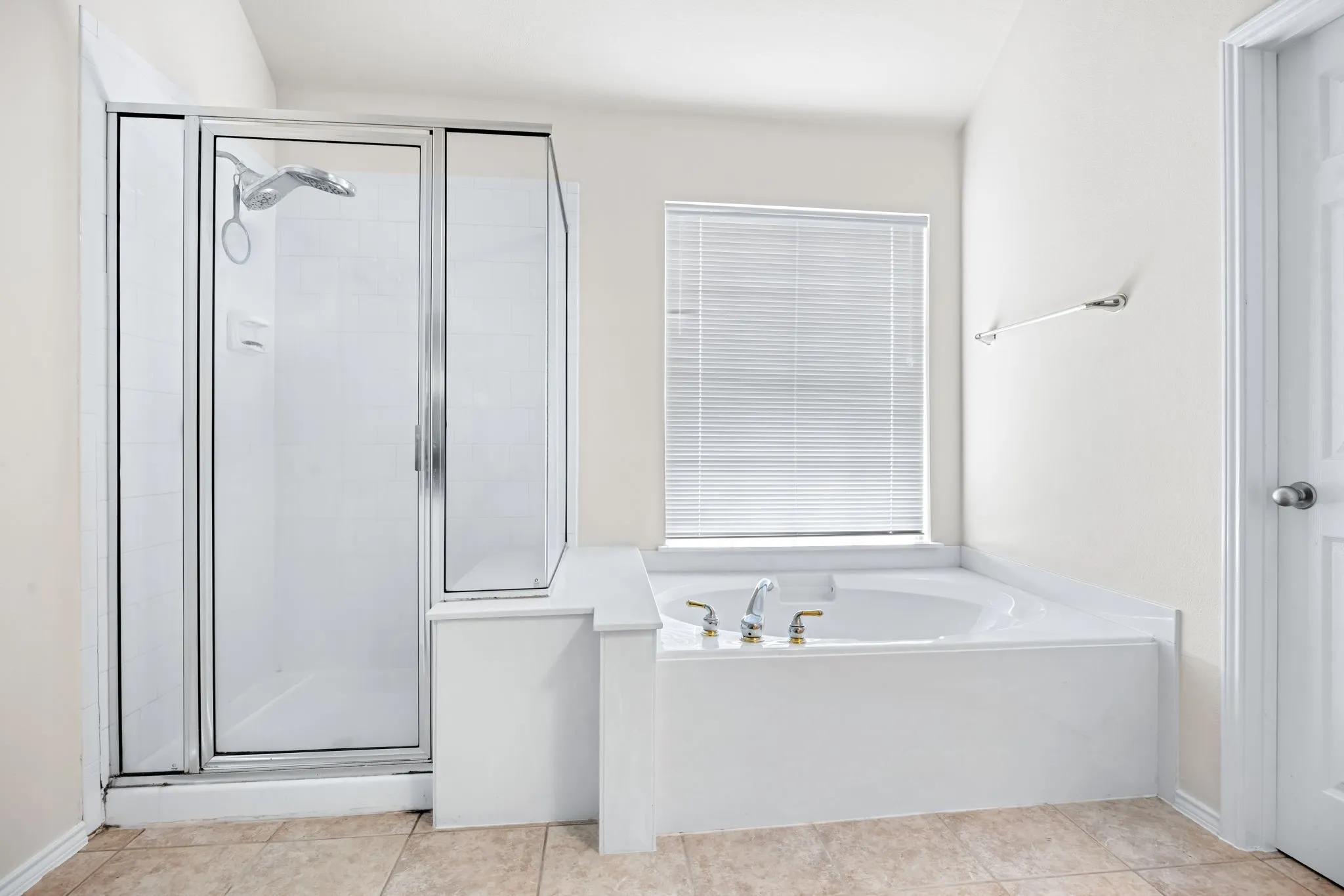 Full bath featuring a garden tub, a stall shower, and light tile patterned floors