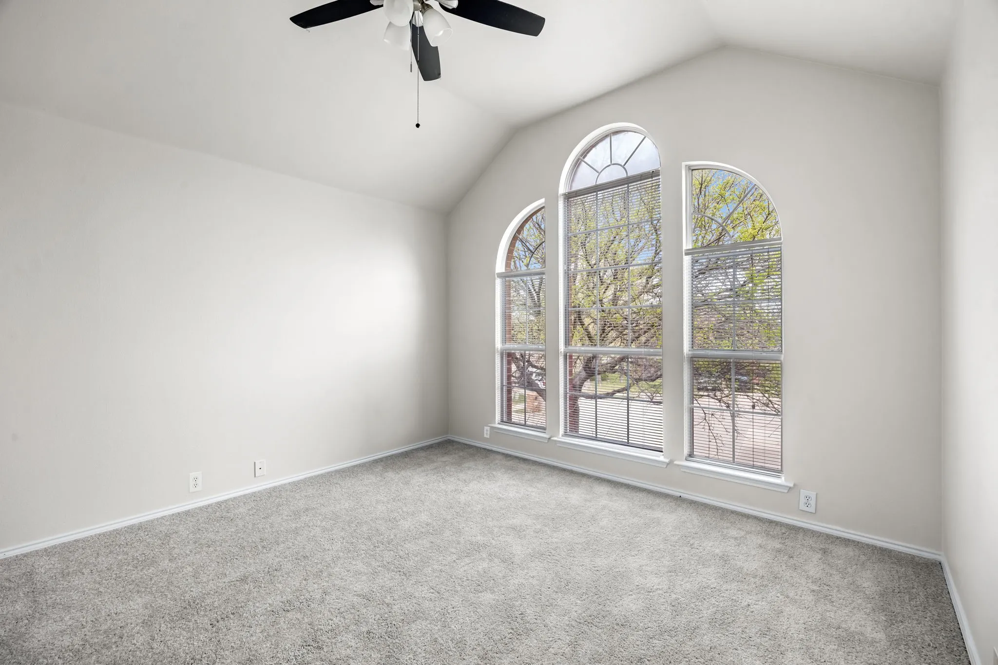 Carpeted empty room featuring a ceiling fan and baseboards