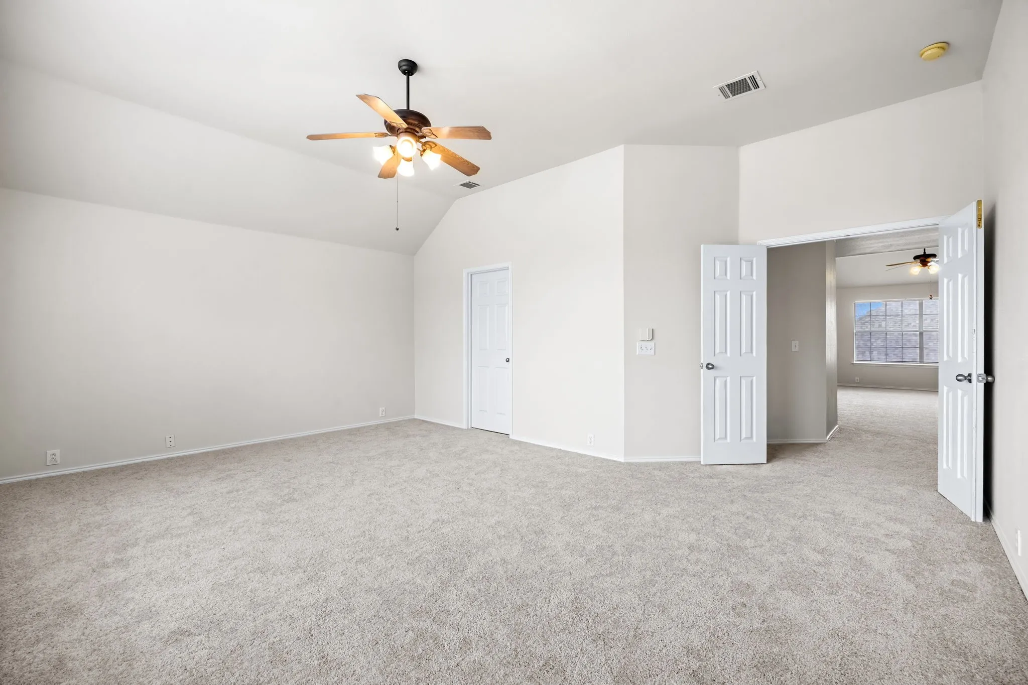 Unfurnished bedroom with carpet, a ceiling fan, and lofted ceiling