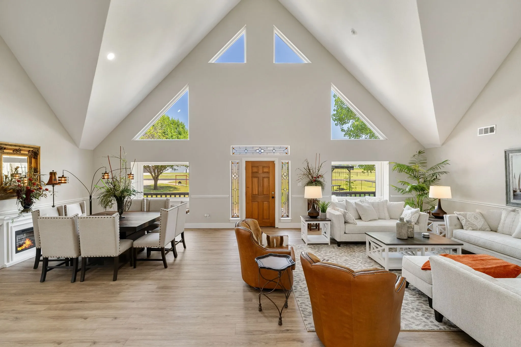 Vaulted ceilings define this expansive living area, featuring an impressive arrangement of triangular and rectangular windows
