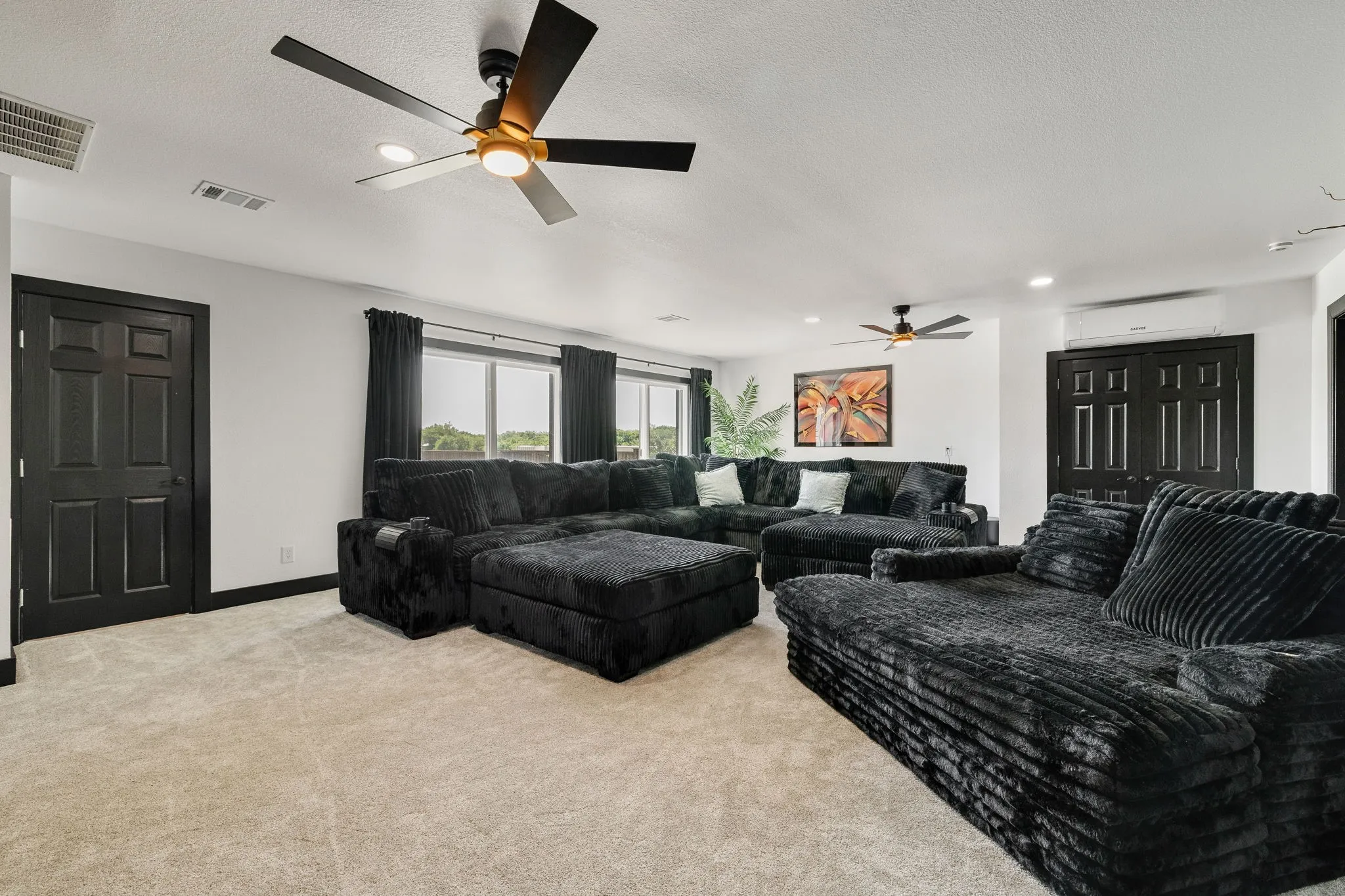 Spacious interior room featuring light-toned carpeting and white walls