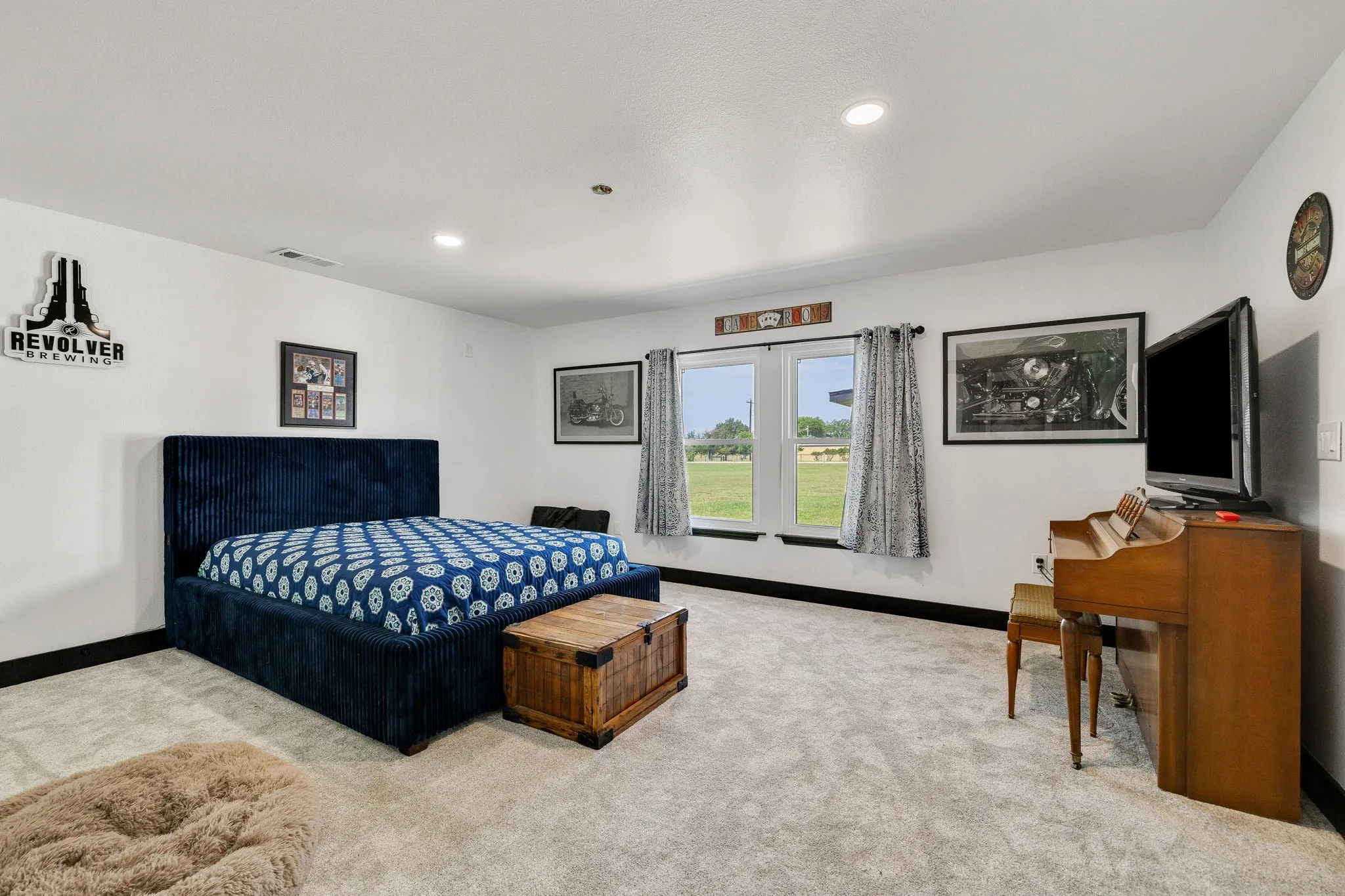 Carpeted room featuring white walls with black trim, recessed lighting, and two windows offering exterior views