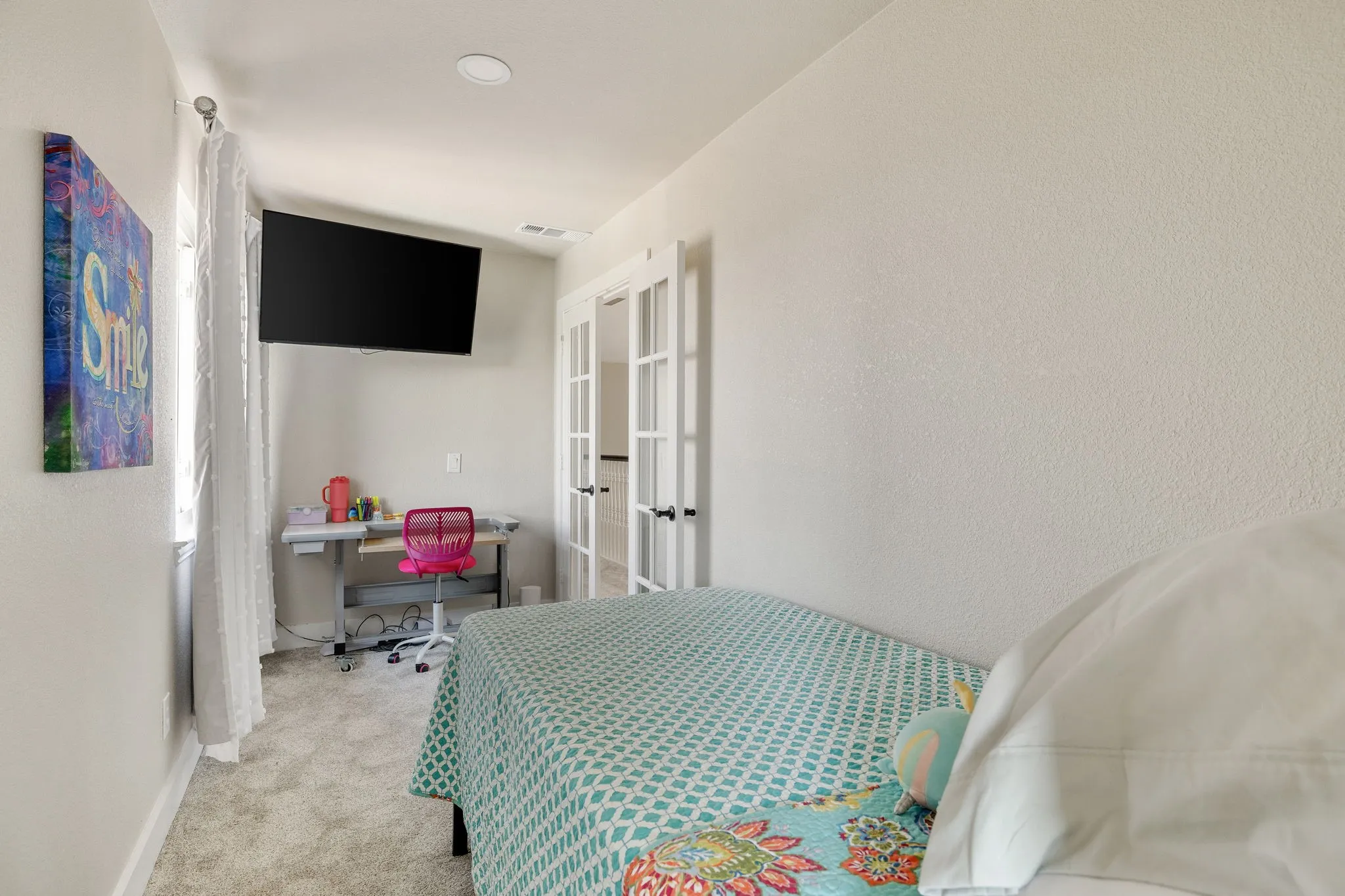 Carpeted room featuring a built-in wall-mounted television, recessed lighting, and French doors with glass panels