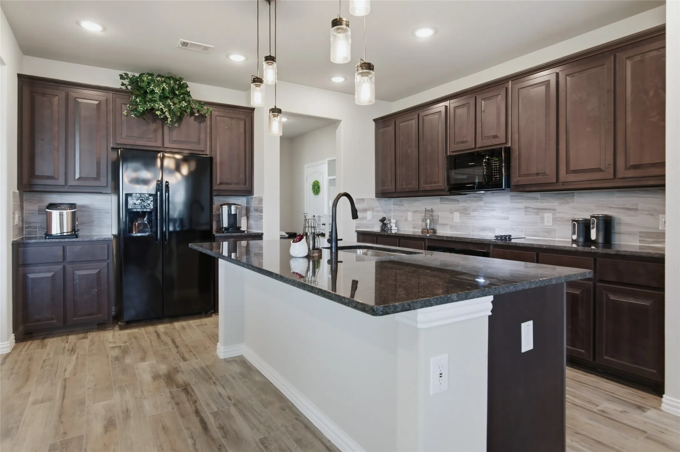 Quartz countertops, modern lighting over the kitchen island