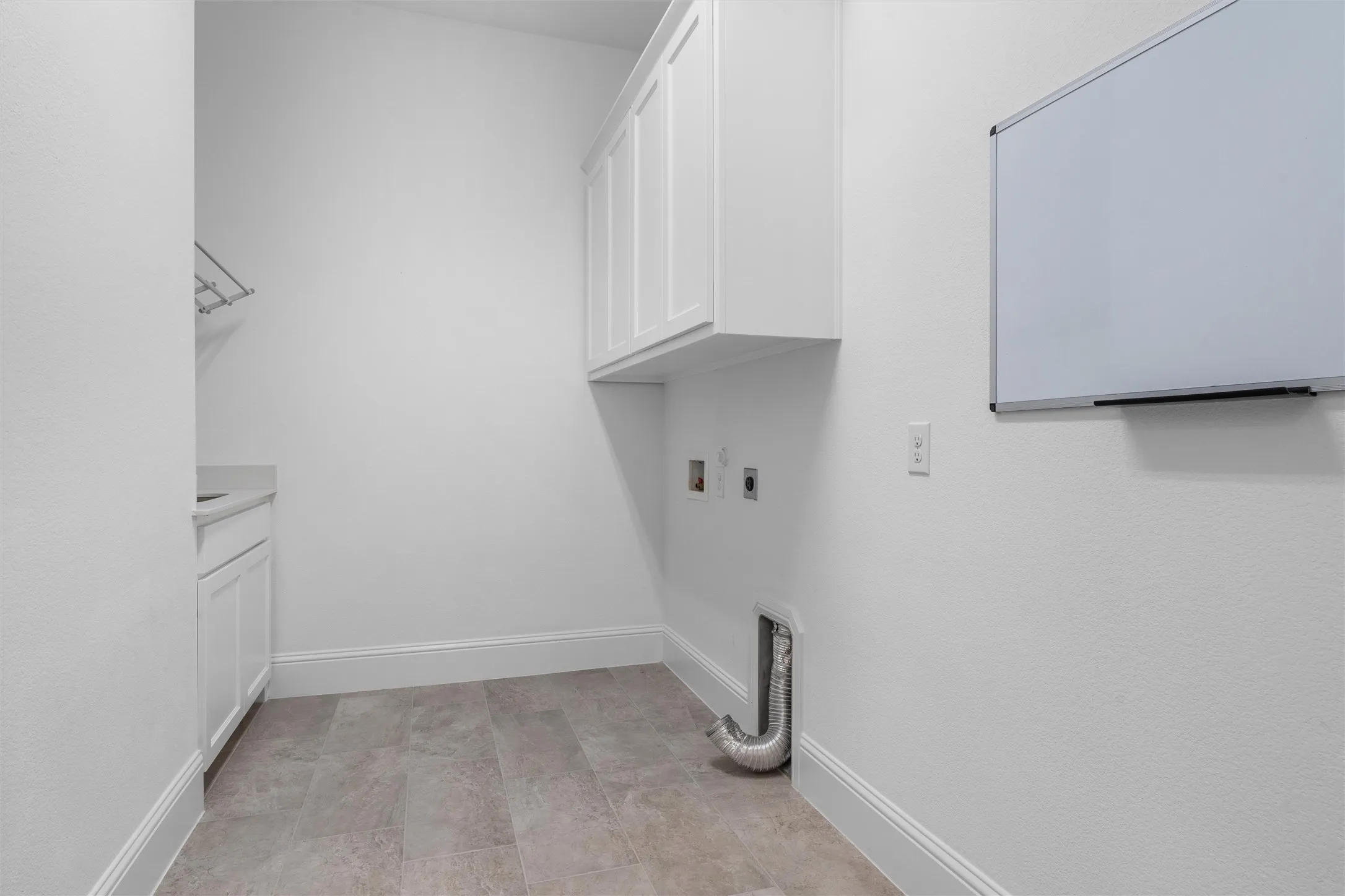 The dedicated utility room adds serious everyday convenience with built-in upper cabinetry, washer-and-dryer connections, durable flooring, and space for laundry essentials and organization.