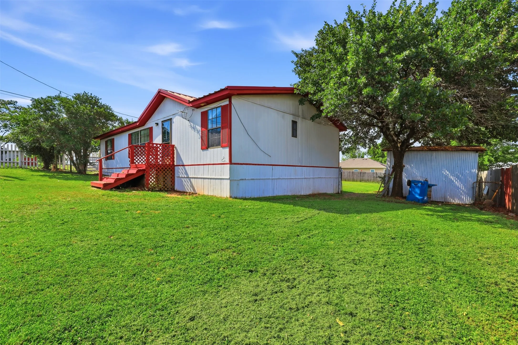 Yard and side view of home. Also shows one of the sheds.