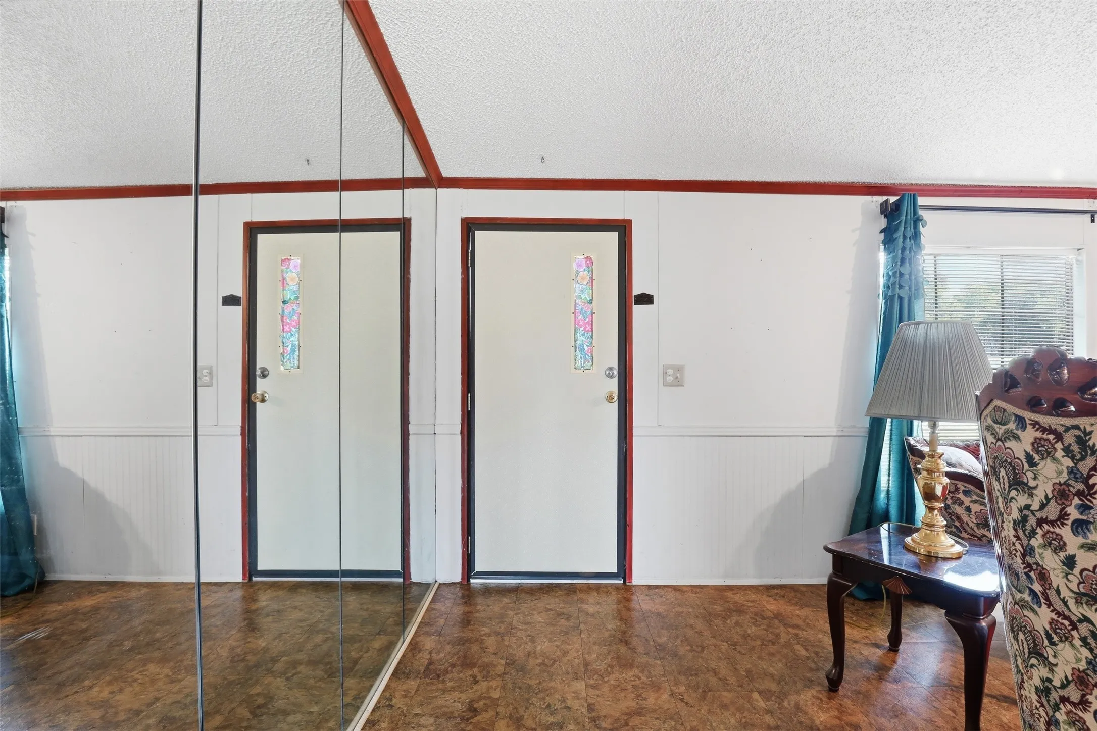 Front entry into living room. Mirrored wall.