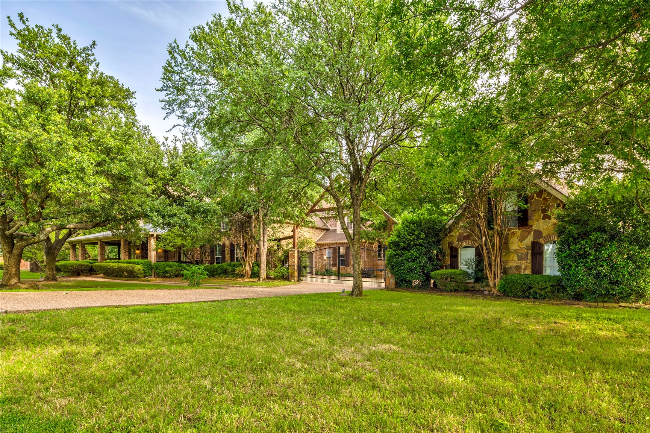 Gated driveway opens to a 3 car attached garage and an additional 3 car detached garage with deck & huge upstairs storage room.