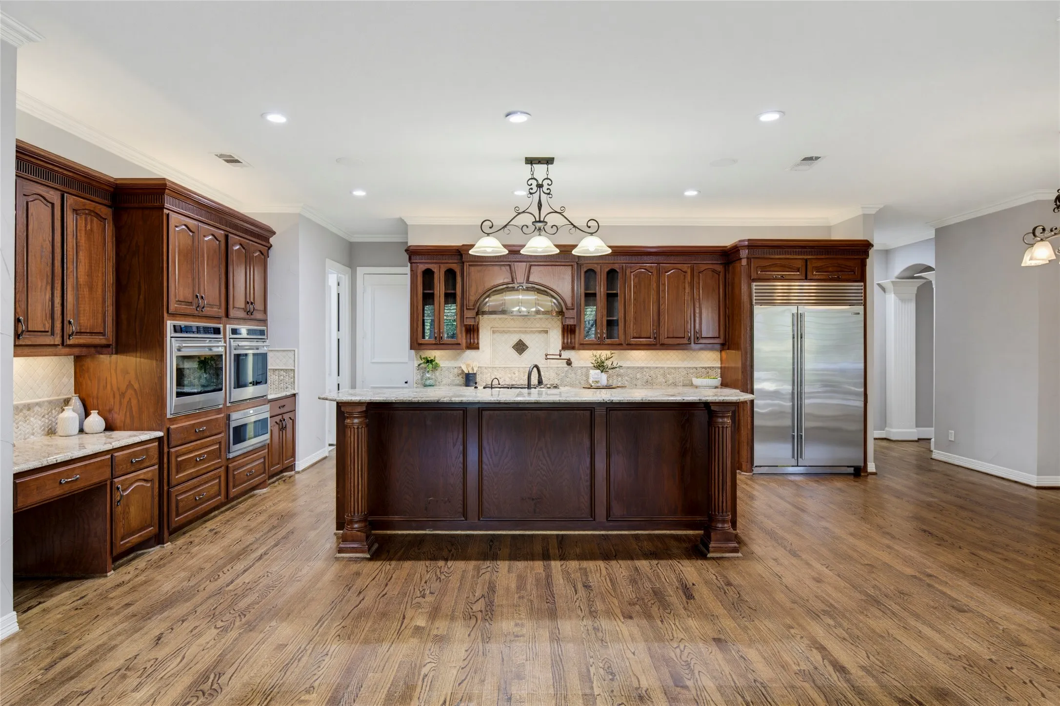Kitchen features Wolfe and Sub-Zero Appliances, a Hoshizaki sonic ice maker, granite counters, a copper hood over the gas cooktop, a walk-in pantry, and plenty of cabinets for storage.