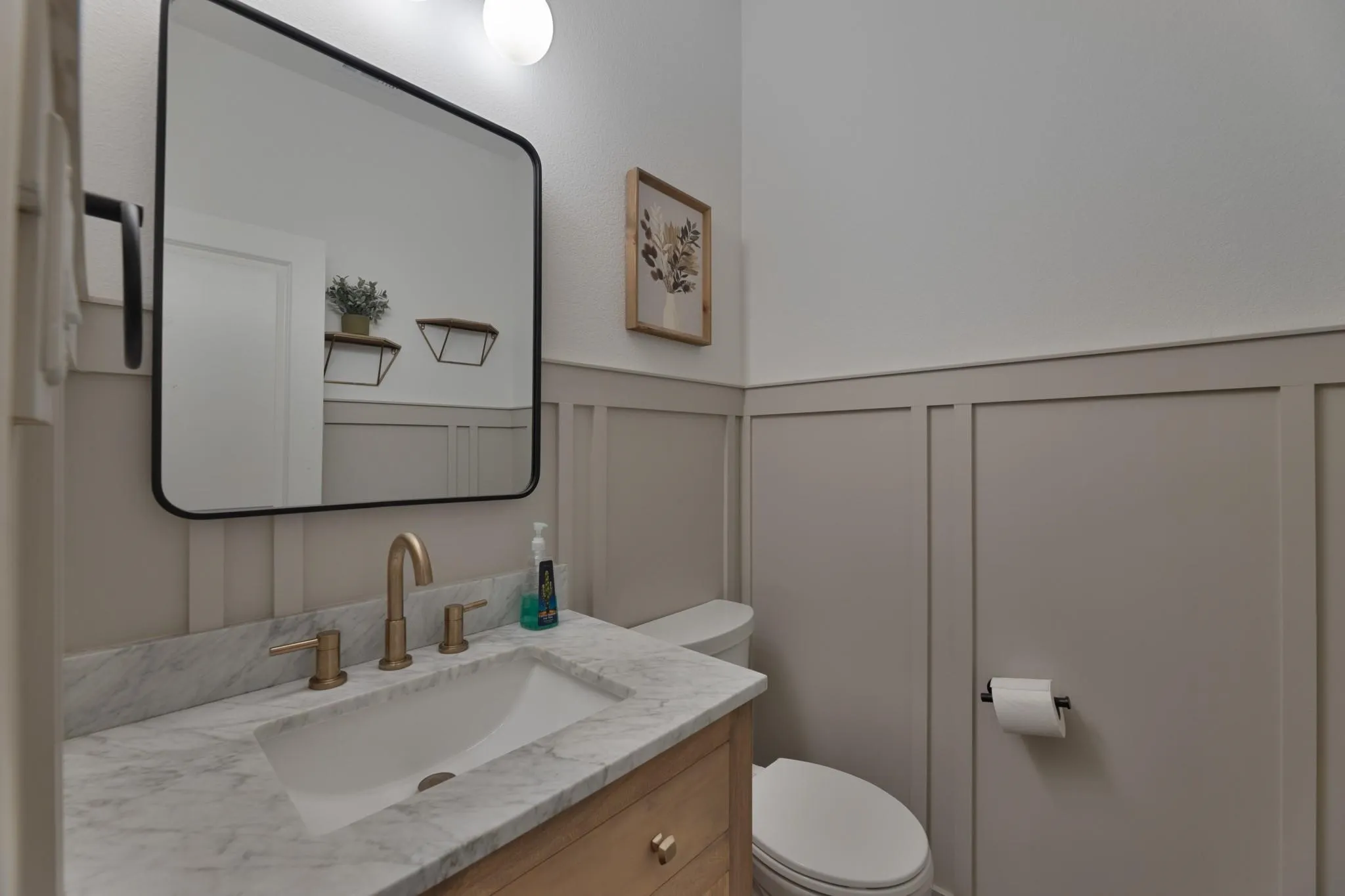 Vanity with a rectangular undermount sink, integrated marble-look countertop, and brass-finish faucet