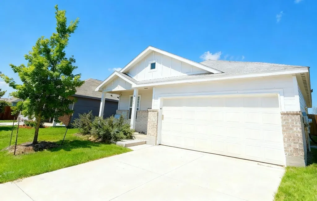 Contemporary single-story residence with a two-car garage, concrete driveway, and front porch
