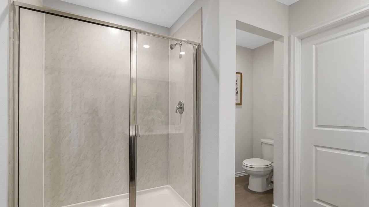 Enclosed shower with glass sliding doors, textured shower surround, and chrome fixtures