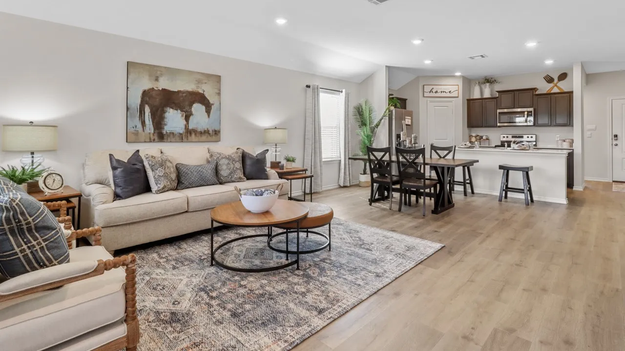 Spacious open-concept living area featuring light wood-finish flooring, recessed lighting, and a neutral color palette